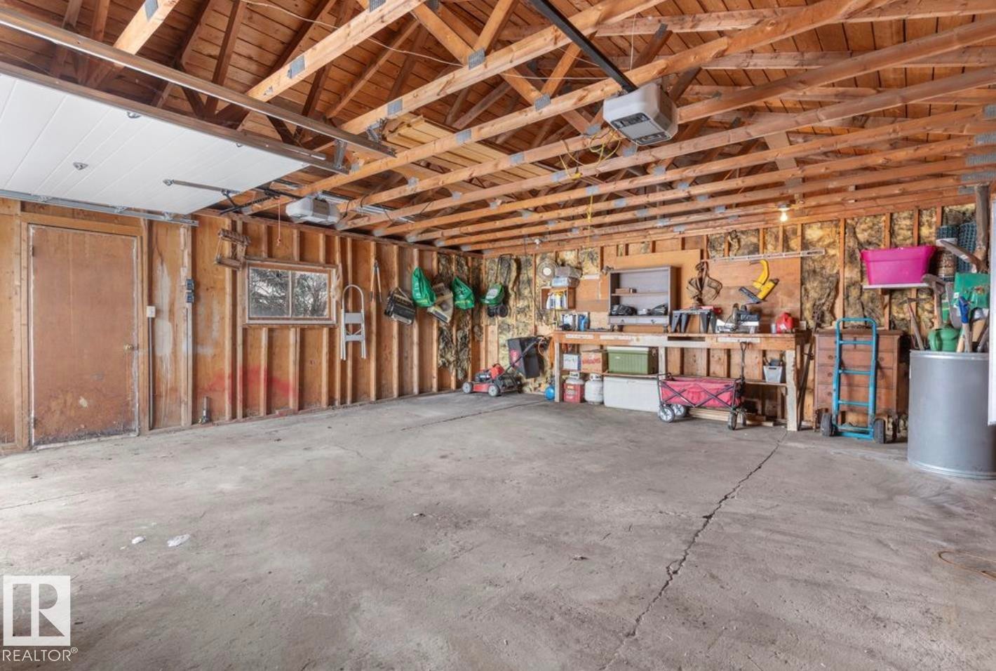Garage with a garage door opener and wood walls - 3810 110 Avenue, Edmonton, AB - Indoor Photo Showing Garage