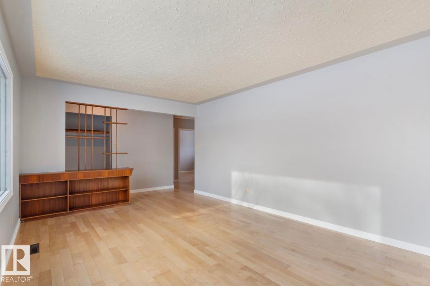 Empty room featuring light wood-type flooring and a textured ceiling - 3810 110 Avenue, Edmonton, AB - Indoor Photo Showing Other Room