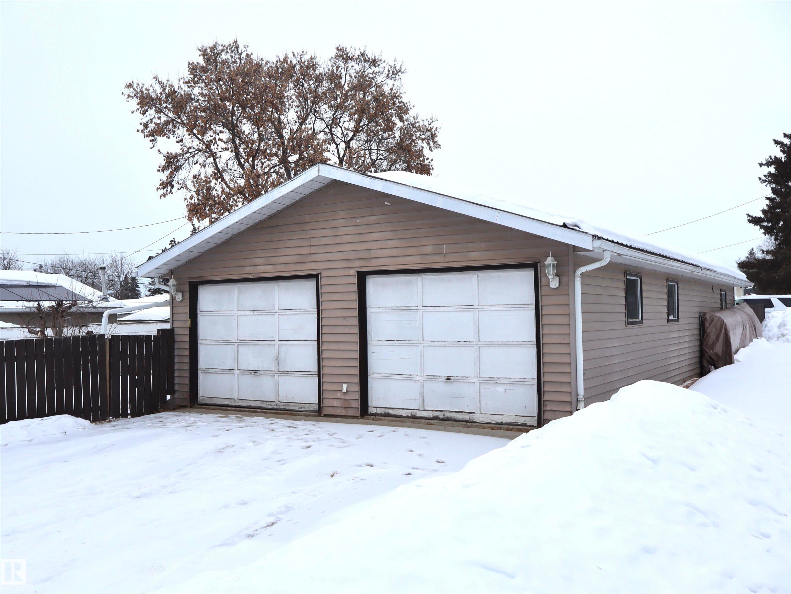Snow covered garage featuring a garage - 4511 53 Ave, Barrhead, AB - Outdoor