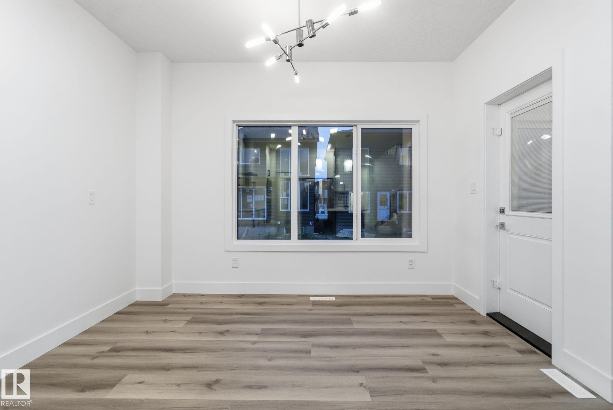 Unfurnished dining area featuring light wood-style floors and baseboards - 2532 210 Street, Edmonton, AB - Indoor Photo Showing Other Room