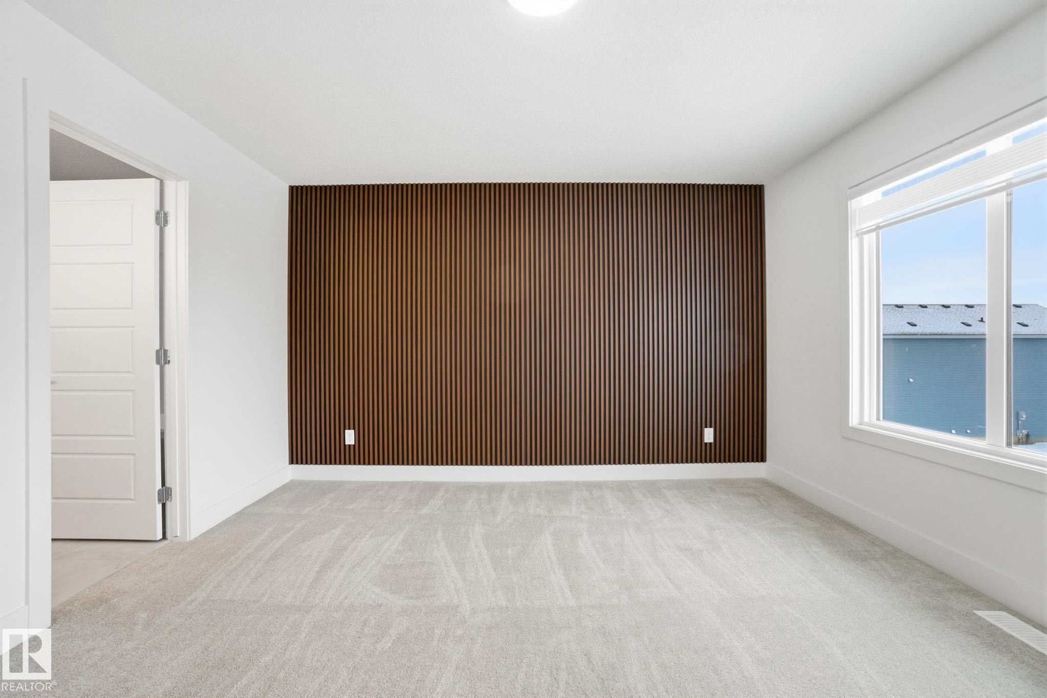 Empty room with an accent wall, wood walls, and light colored carpet - 2532 210 Street, Edmonton, AB - Indoor Photo Showing Other Room