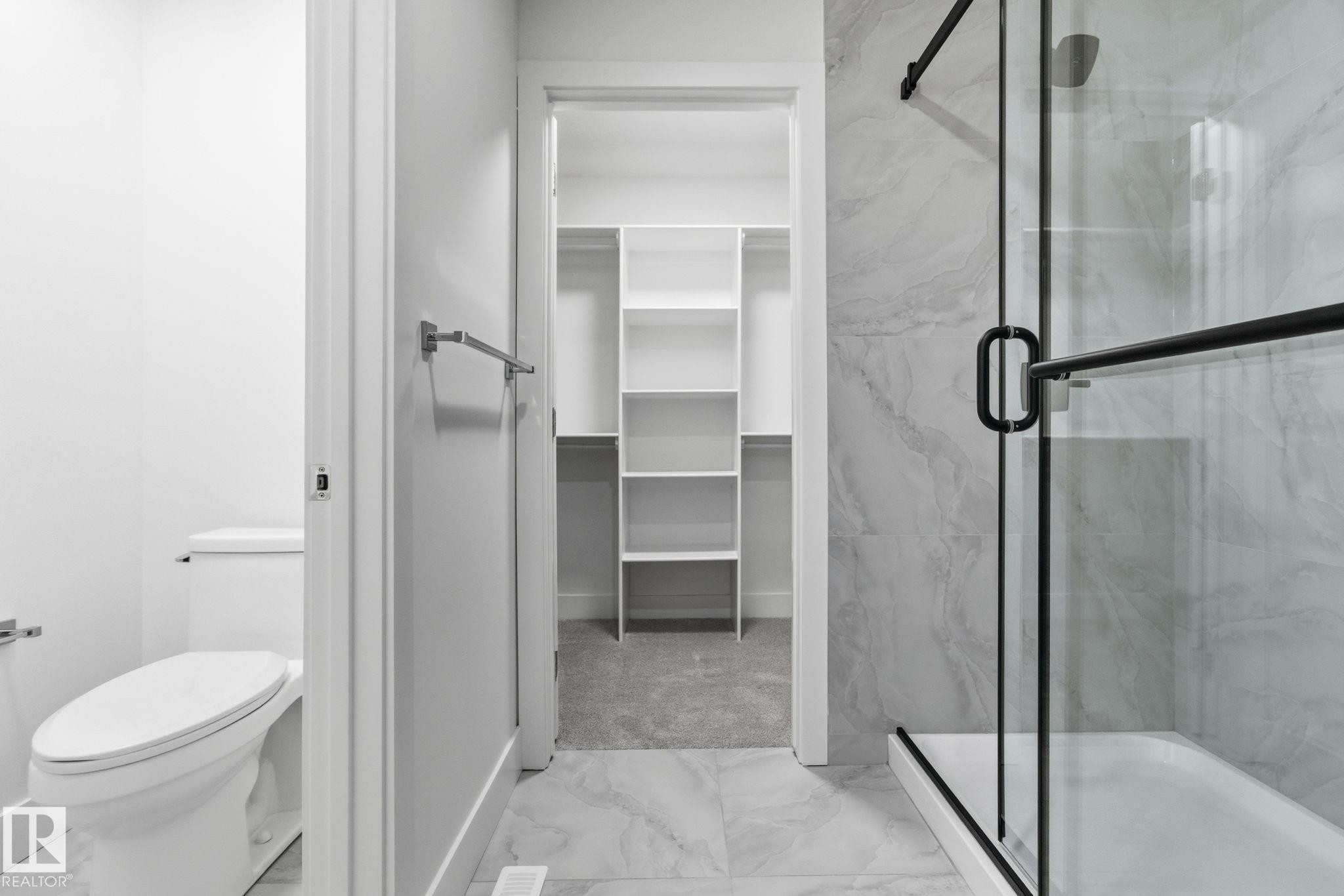 Full bathroom with a marble finish shower, light marble finish floors, and a walk in closet - 2532 210 Street, Edmonton, AB - Indoor Photo Showing Bathroom