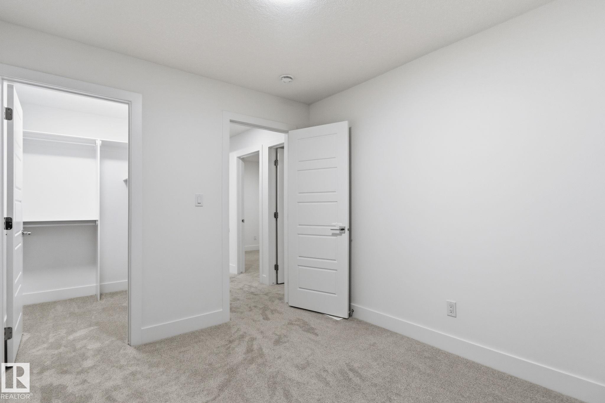 Unfurnished bedroom with a spacious closet and light colored carpet - 2532 210 Street, Edmonton, AB - Indoor