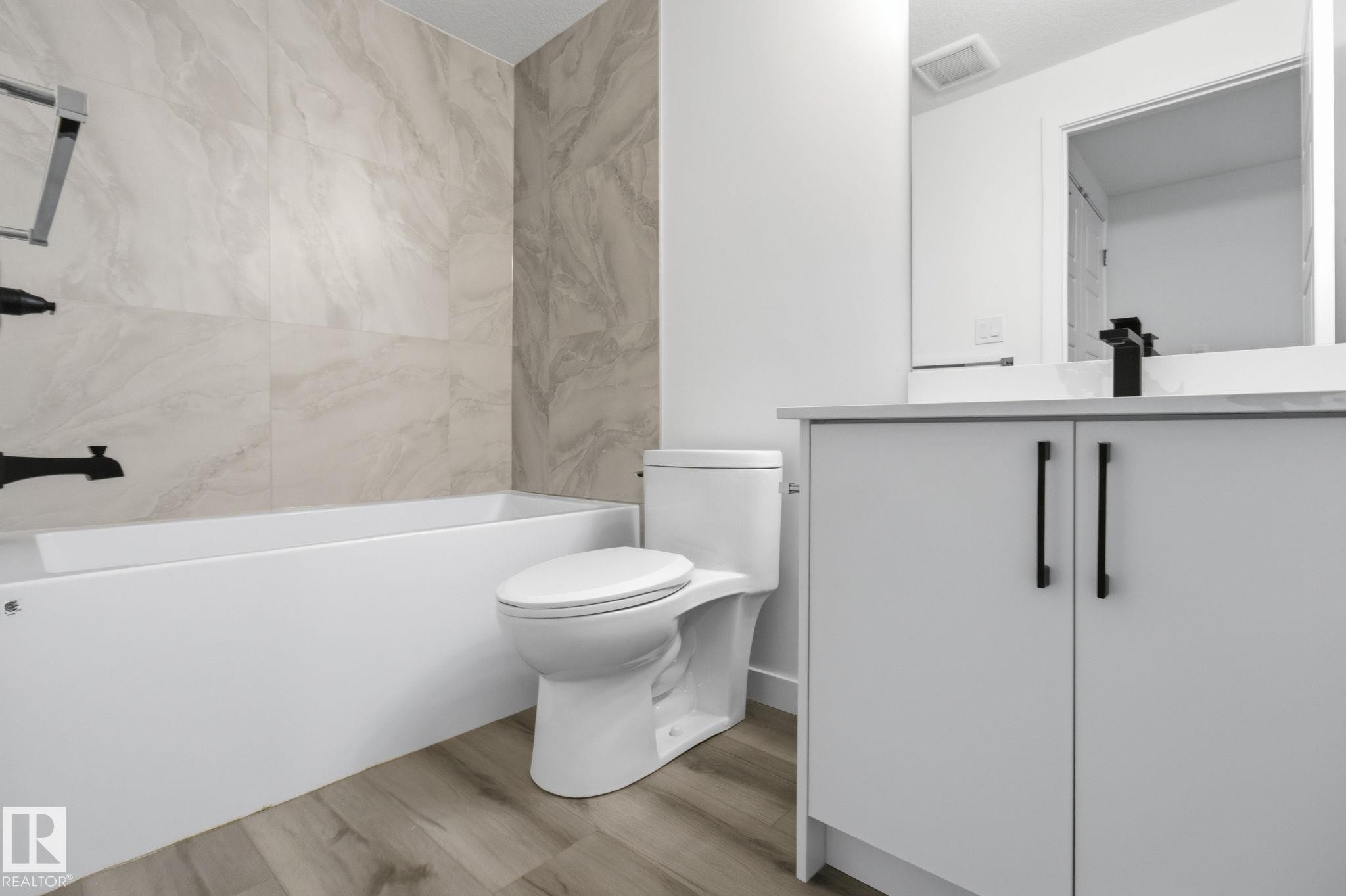 Full bath with vanity, light wood finished floors, and washtub / shower combination - 2532 210 Street, Edmonton, AB - Indoor Photo Showing Bathroom