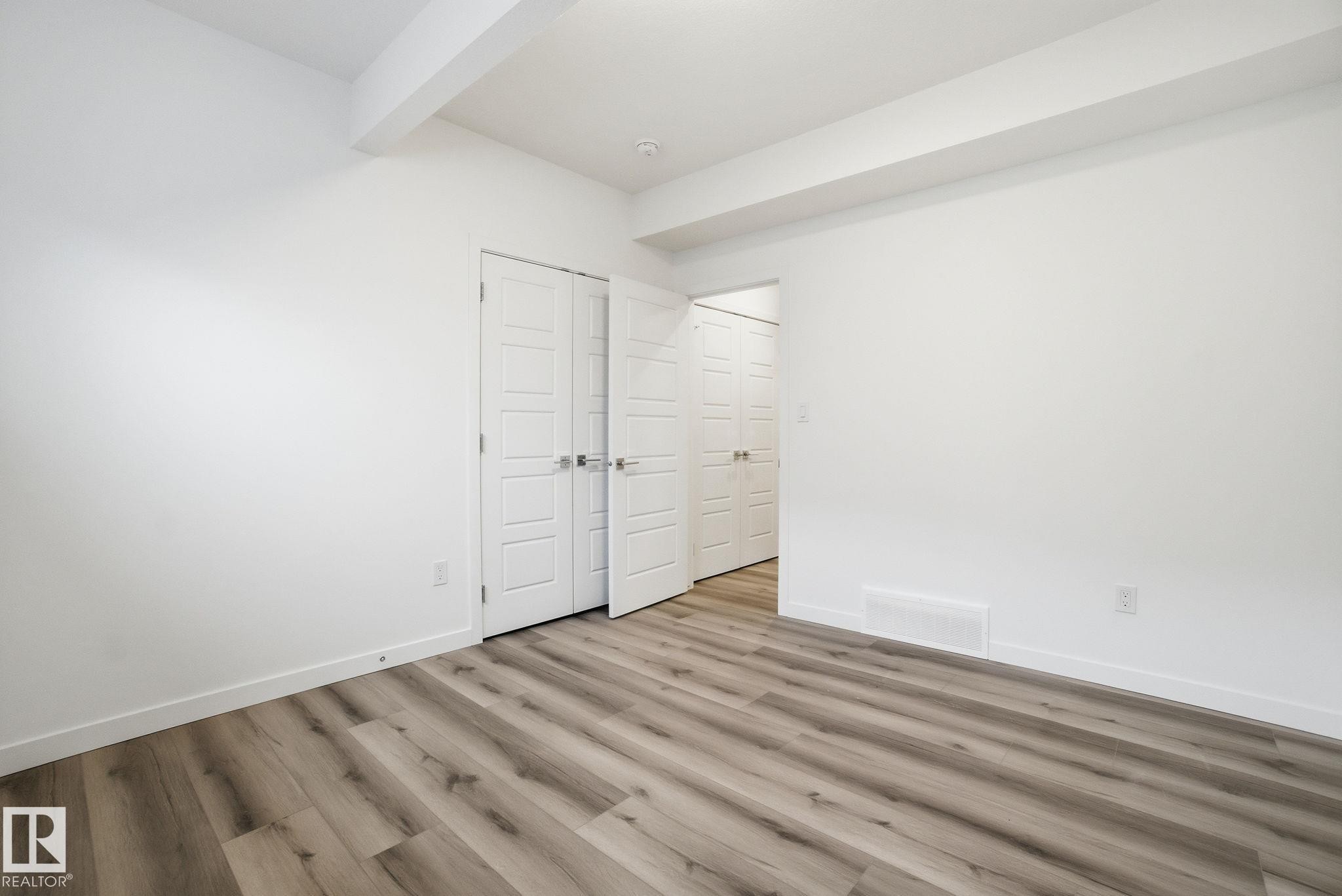 Unfurnished bedroom featuring light wood-style flooring, beam ceiling, and a closet - 2532 210 Street, Edmonton, AB - Indoor Photo Showing Other Room