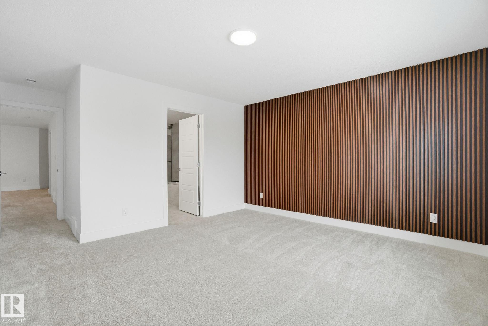 Carpeted spare room featuring an accent wall and wooden walls - 2532 210 Street, Edmonton, AB - Indoor Photo Showing Other Room