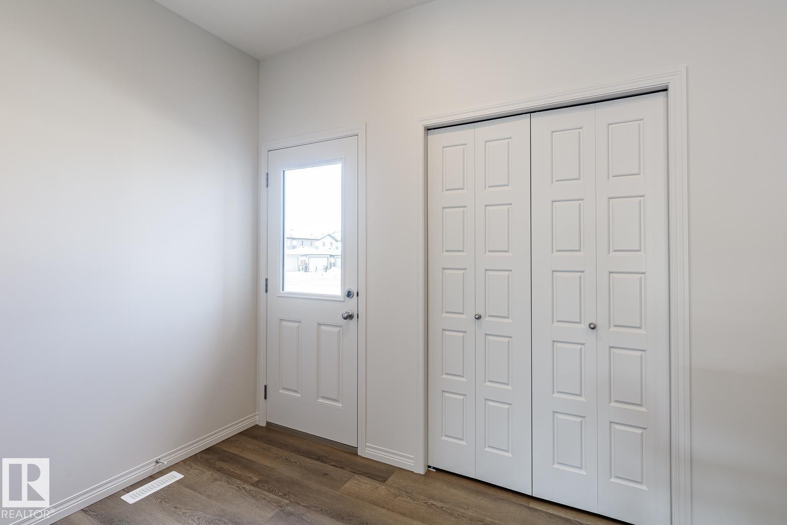 Foyer with dark wood-style floors and baseboards - 3617 Triomphe Boulevard, Beaumont, AB - Indoor Photo Showing Other Room