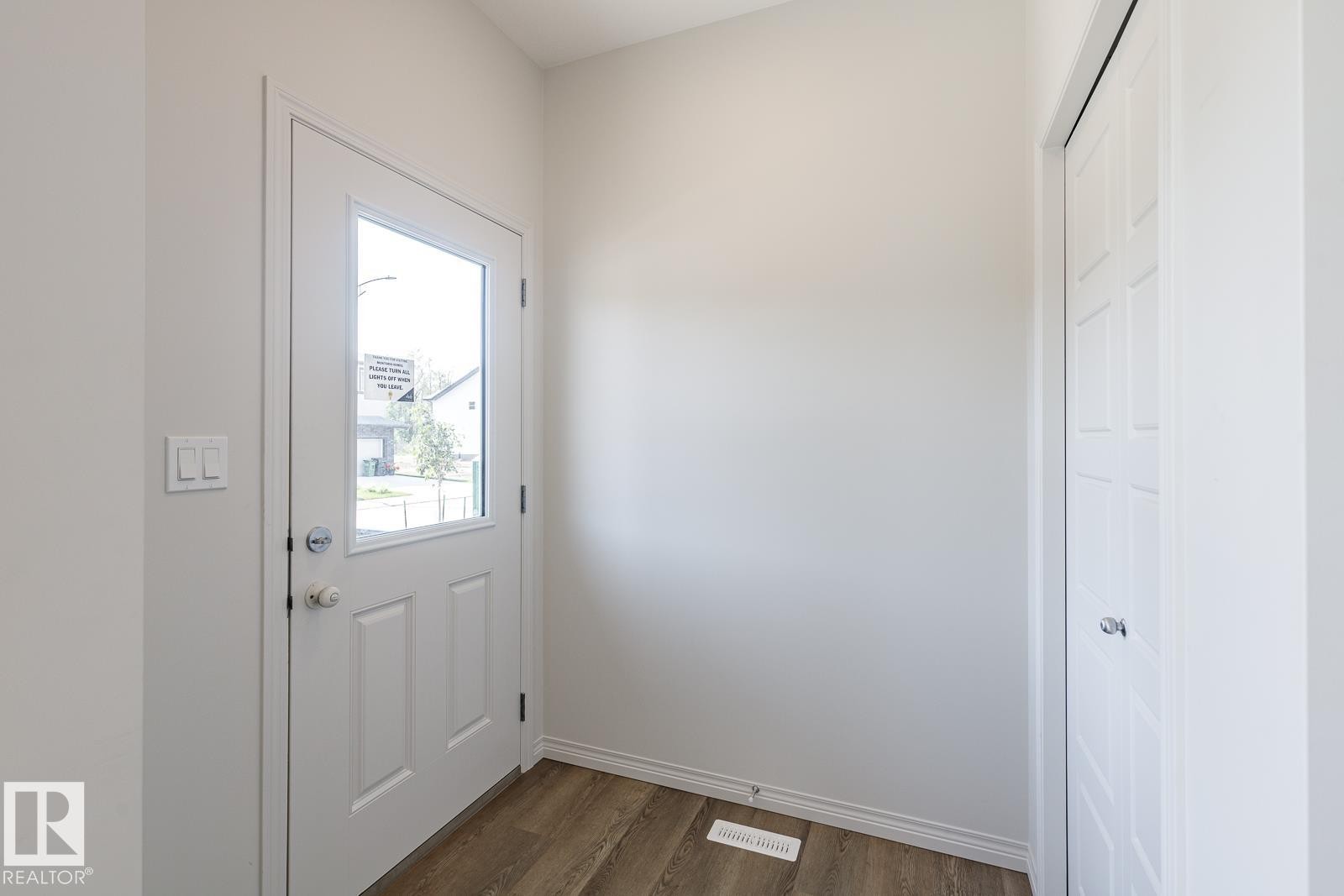 Doorway featuring wood finished floors and baseboards - 3617 Triomphe Boulevard, Beaumont, AB - Indoor Photo Showing Other Room