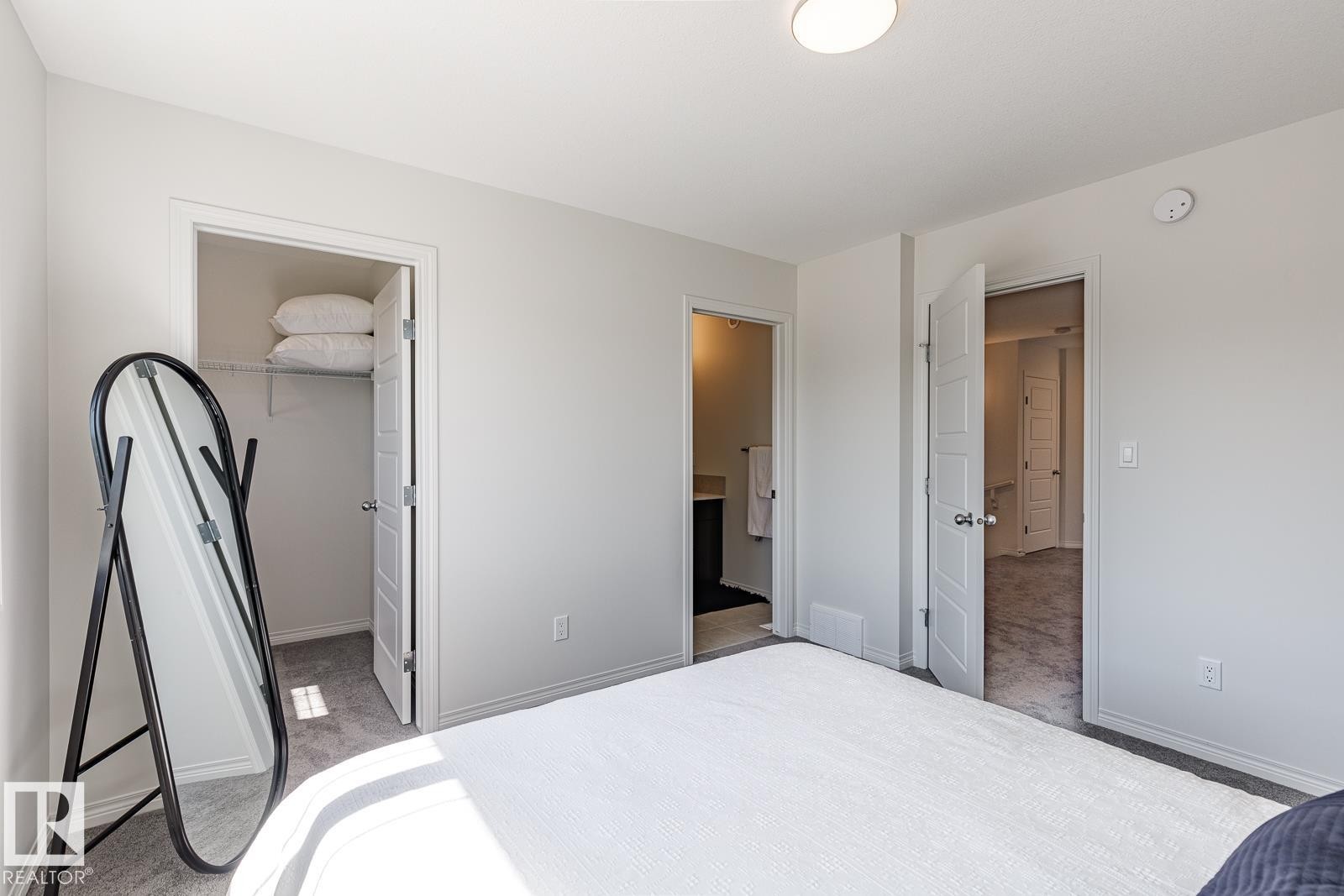 Bedroom with light colored carpet, a walk in closet, and ensuite bathroom - 3617 Triomphe Boulevard, Beaumont, AB - Indoor Photo Showing Bedroom