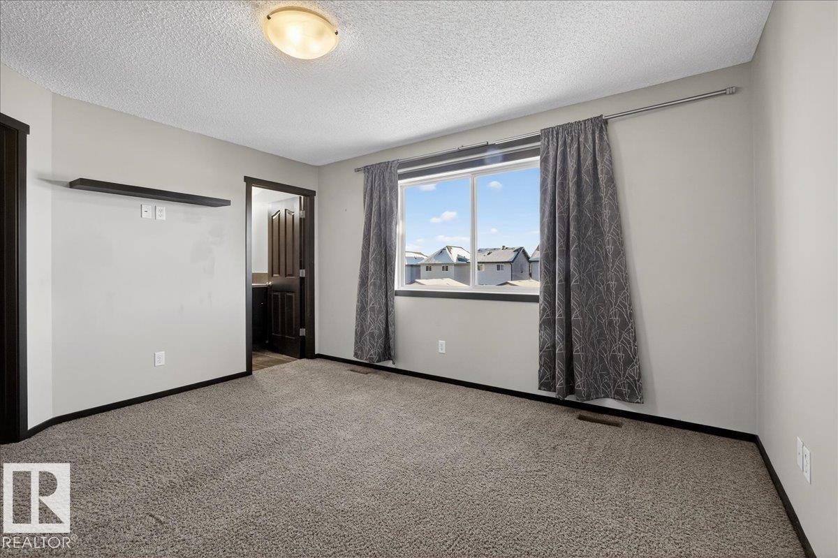 Unfurnished bedroom with carpet and a textured ceiling - 3623 13 Street, Edmonton, AB - Indoor Photo Showing Other Room