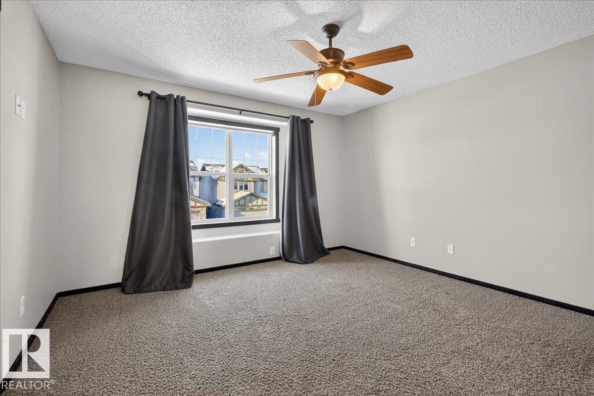 Carpeted empty room with a textured ceiling and a ceiling fan - 3623 13 Street, Edmonton, AB - Indoor Photo Showing Other Room