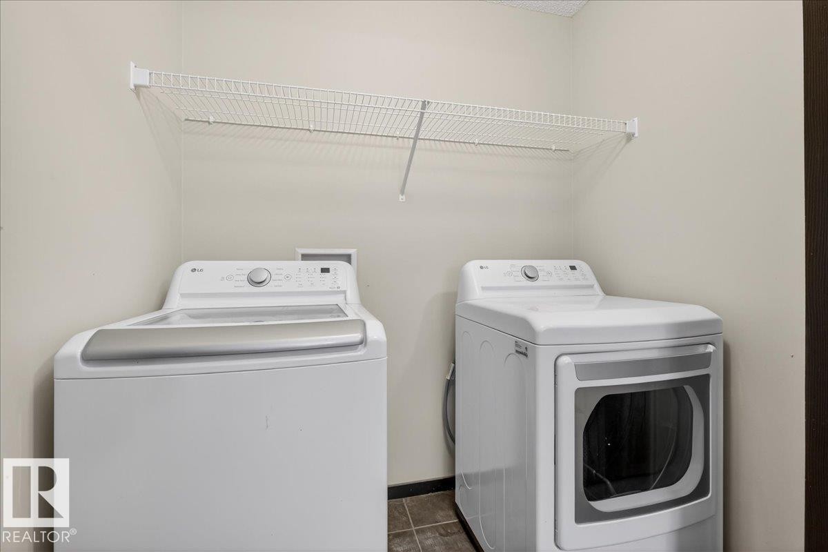 Laundry room featuring washer and dryer and dark tile patterned flooring - 3623 13 Street, Edmonton, AB - Indoor Photo Showing Laundry Room