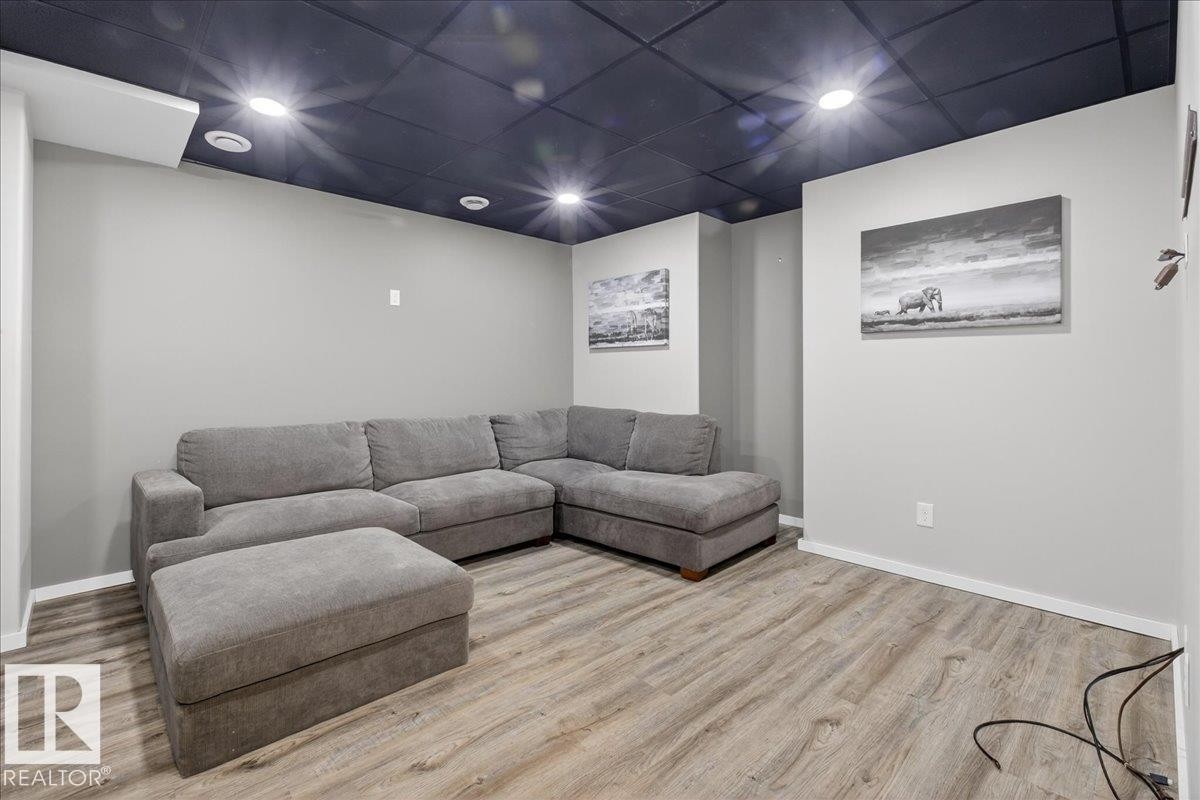 Living room featuring wood finished floors, recessed lighting, and a paneled ceiling - 3623 13 Street, Edmonton, AB - Indoor