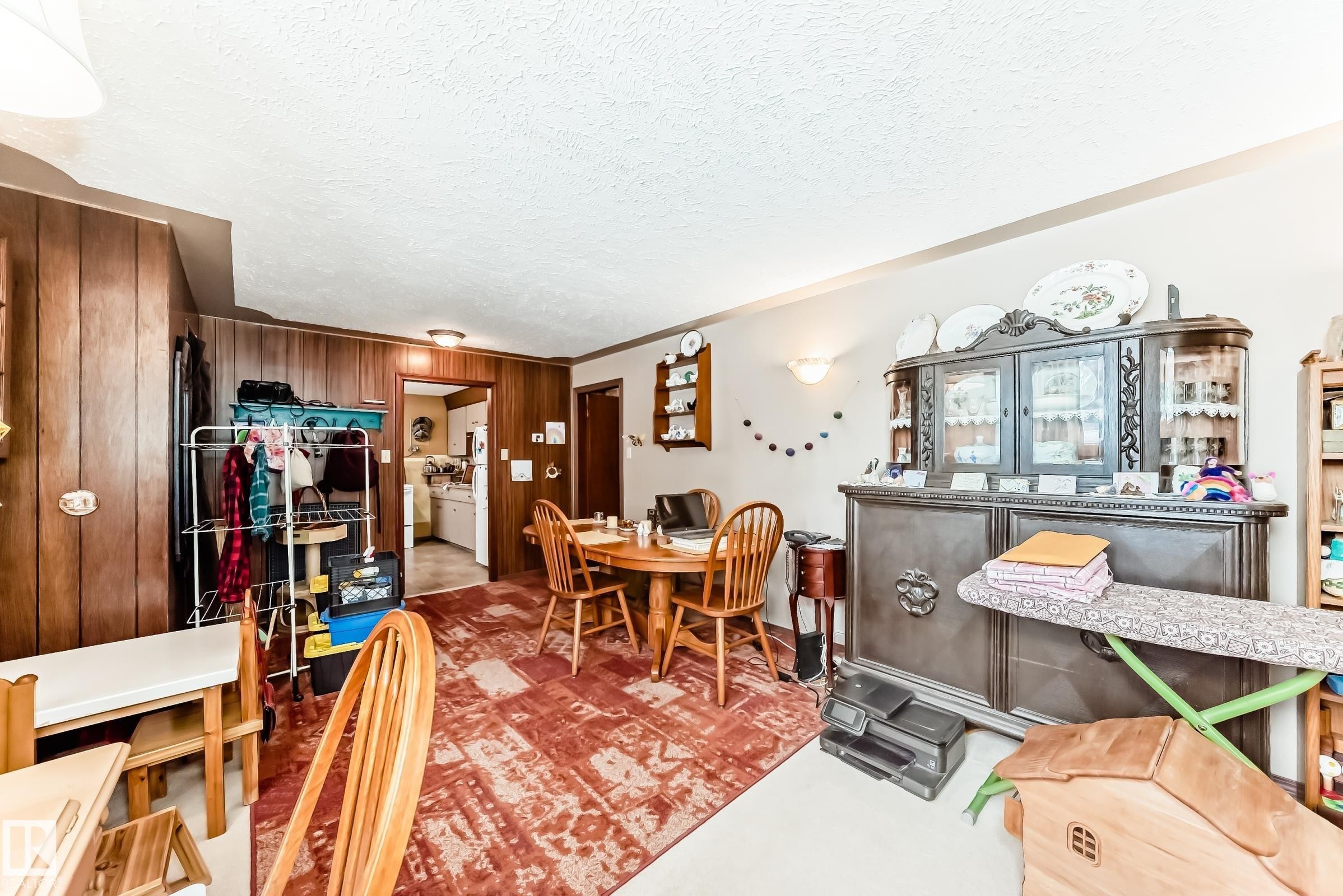 Dining room featuring a textured ceiling and wooden walls - 12028 87 Street, Edmonton, AB - Indoor Photo Showing Dining Room