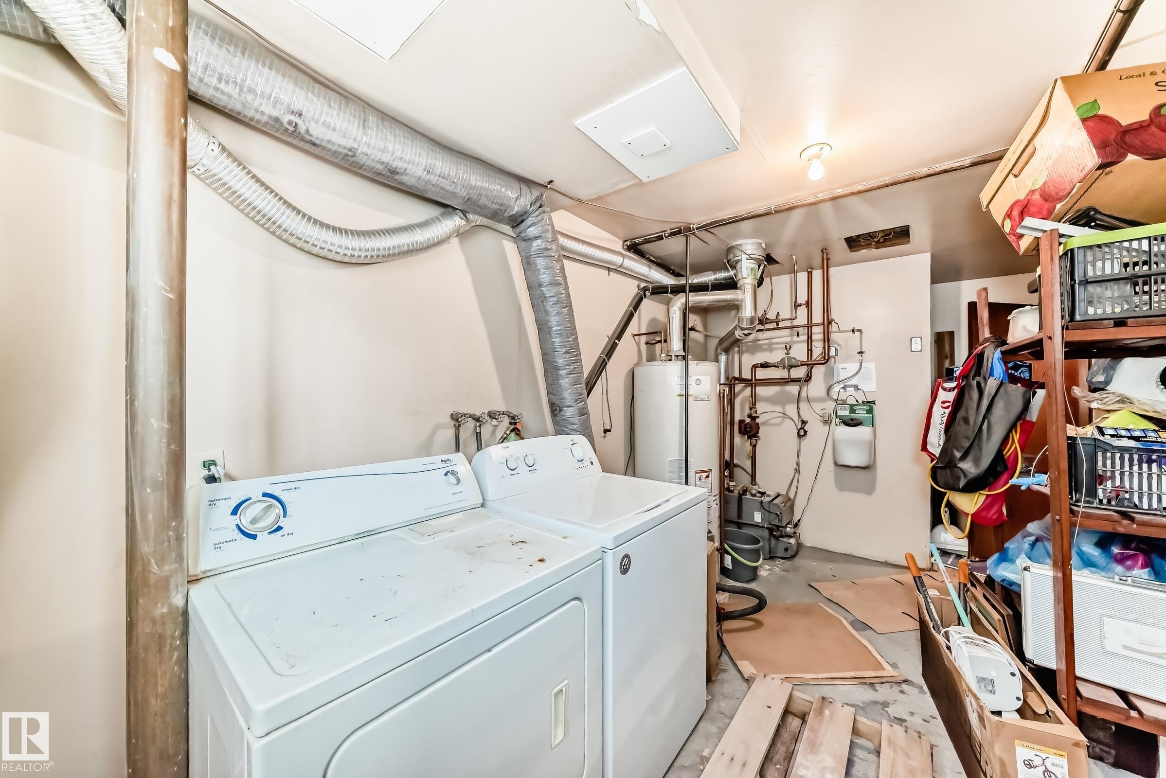 Laundry area featuring unfinished concrete flooring, washer and dryer, and water heater - 12028 87 Street, Edmonton, AB - Indoor Photo Showing Laundry Room
