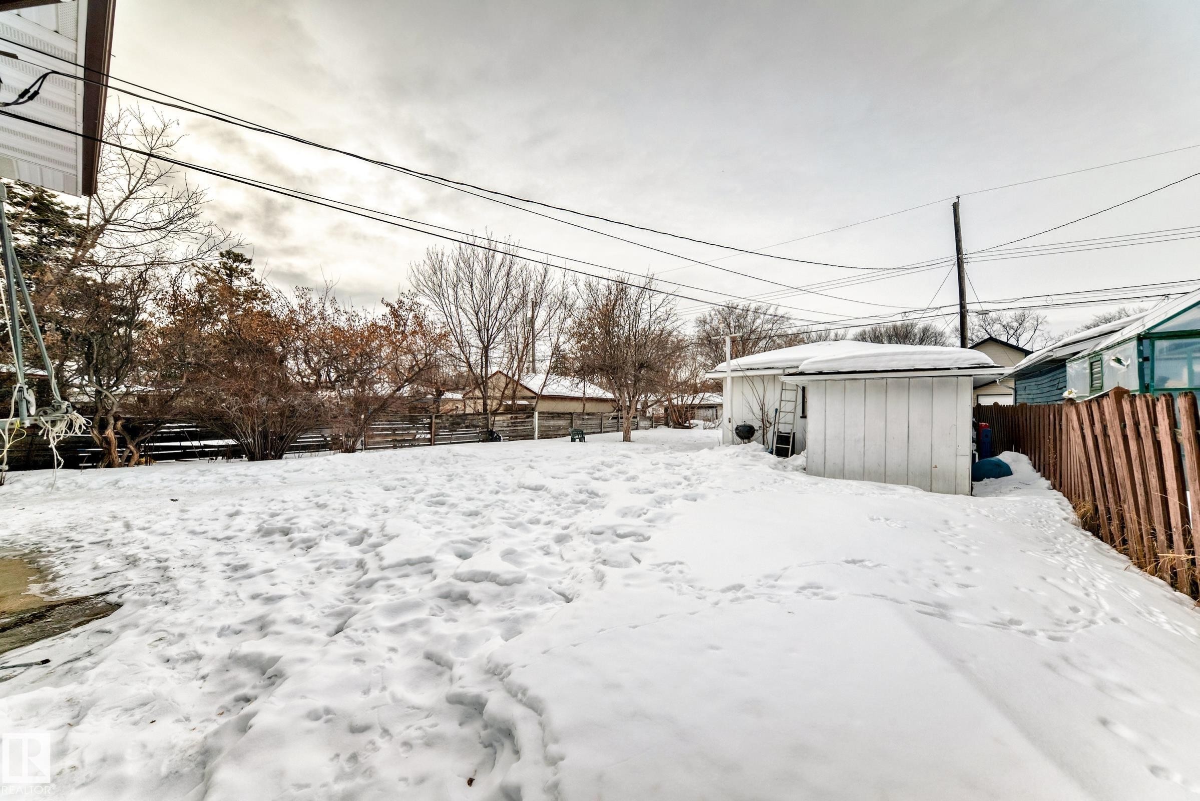 Yard covered in snow featuring a fenced backyard and a shed - 12028 87 Street, Edmonton, AB - Outdoor