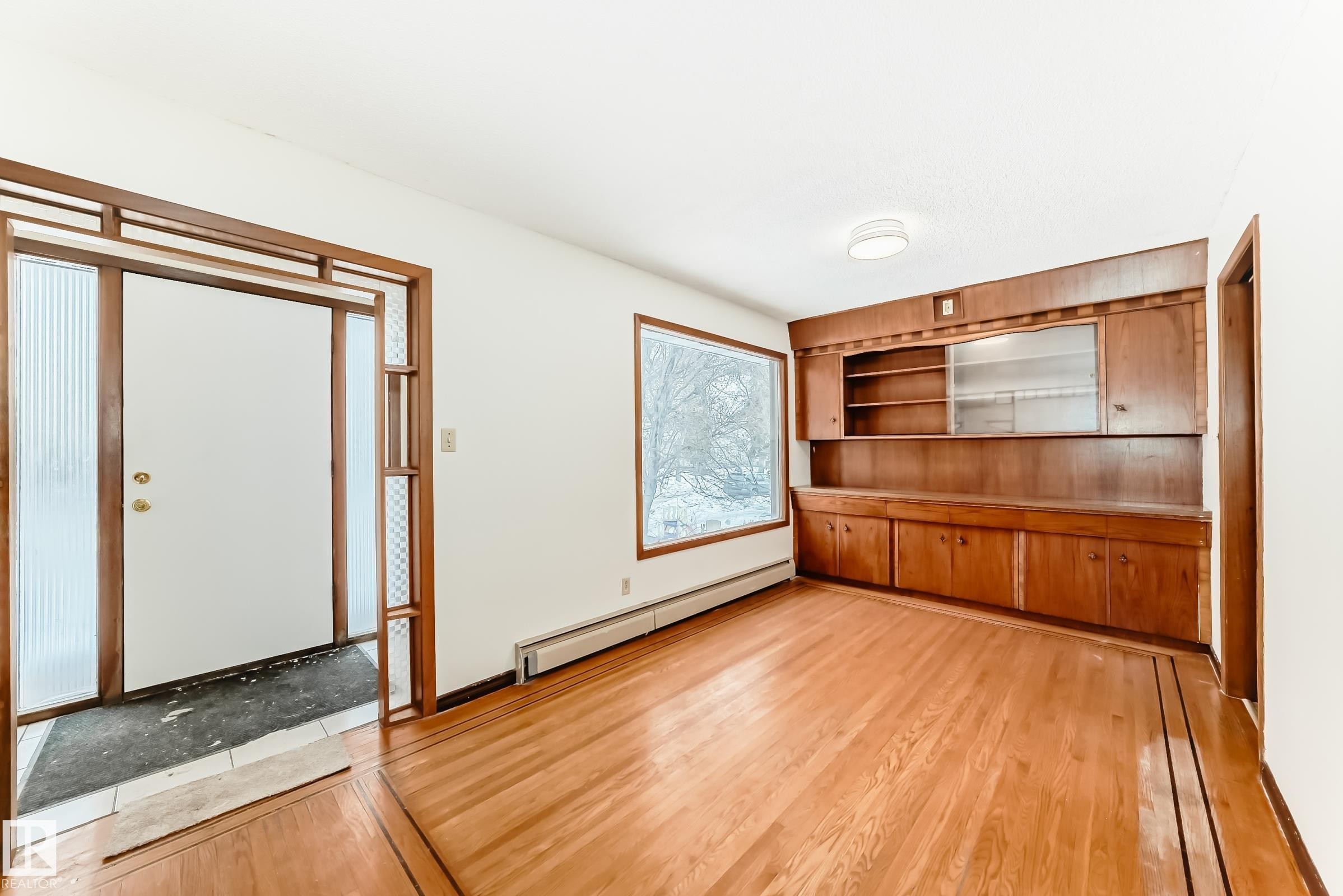 Unfurnished dining area featuring a baseboard radiator and light wood finished floors - 12028 87 Street, Edmonton, AB - Indoor Photo Showing Other Room