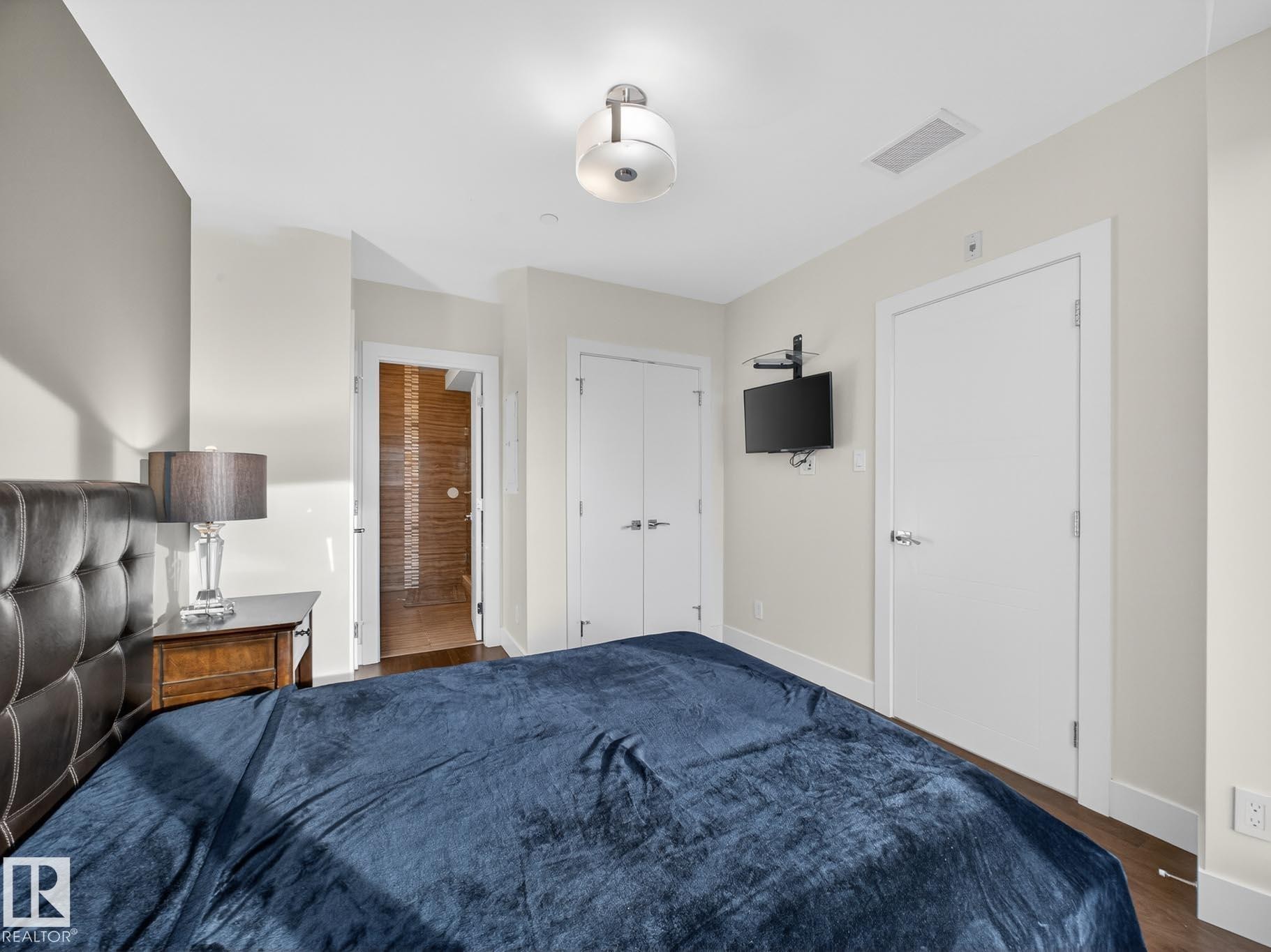 Bedroom featuring dark wood finished floors and a closet - #902 11969 Jasper Av Nw, Edmonton, AB - Indoor Photo Showing Bedroom