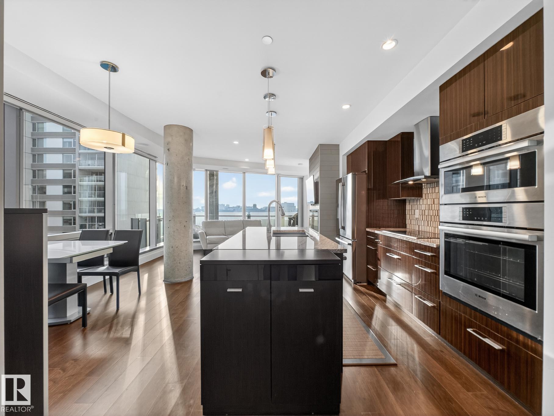 Kitchen featuring modern cabinets, stainless steel appliances, a kitchen island with sink, decorative light fixtures, and recessed lighting - #902 11969 Jasper Av Nw, Edmonton, AB - Indoor Photo Showing Kitchen With Stainless Steel Kitchen With Upgraded Kitchen