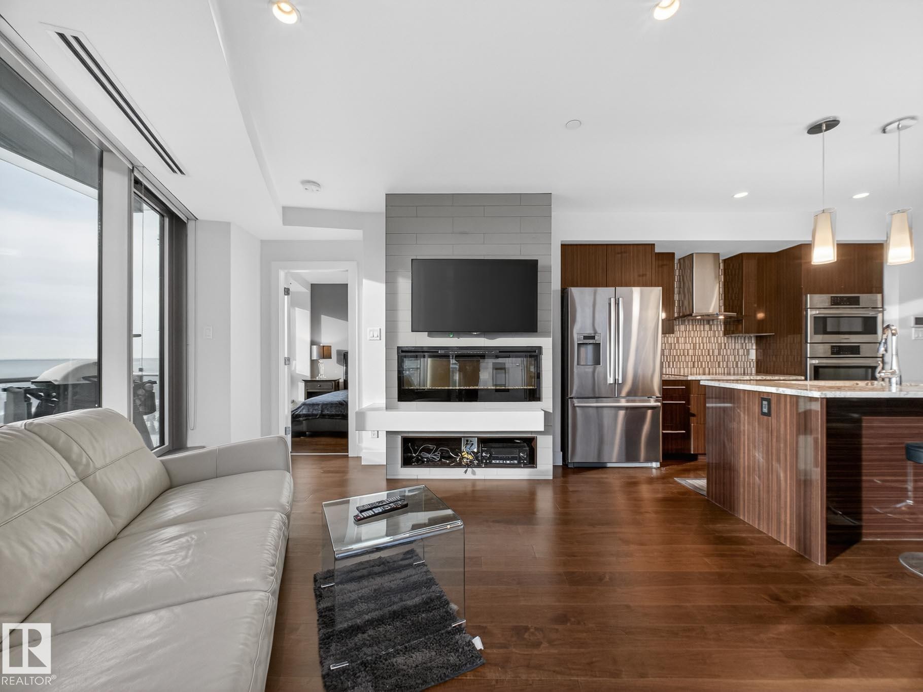 Living room featuring dark wood finished floors - #902 11969 Jasper Av Nw, Edmonton, AB - Indoor