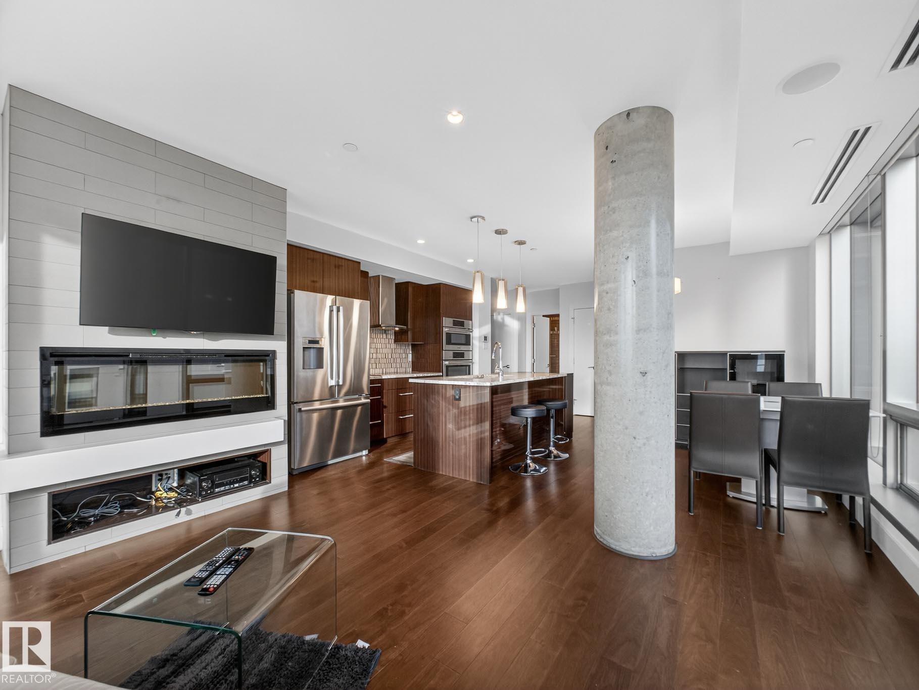 Living room featuring dark wood finished floors - #902 11969 Jasper Av Nw, Edmonton, AB - Indoor Photo Showing Kitchen With Stainless Steel Kitchen With Upgraded Kitchen