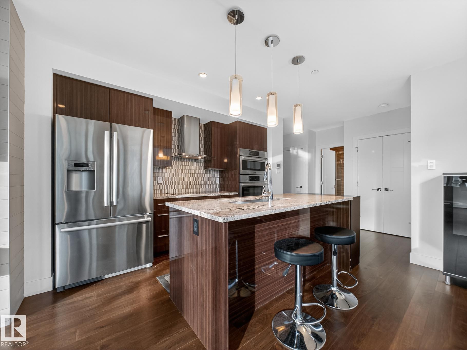 Kitchen with modern cabinets, stainless steel appliances, light stone counters, pendant lighting, and recessed lighting - #902 11969 Jasper Av Nw, Edmonton, AB - Indoor Photo Showing Kitchen With Stainless Steel Kitchen With Upgraded Kitchen