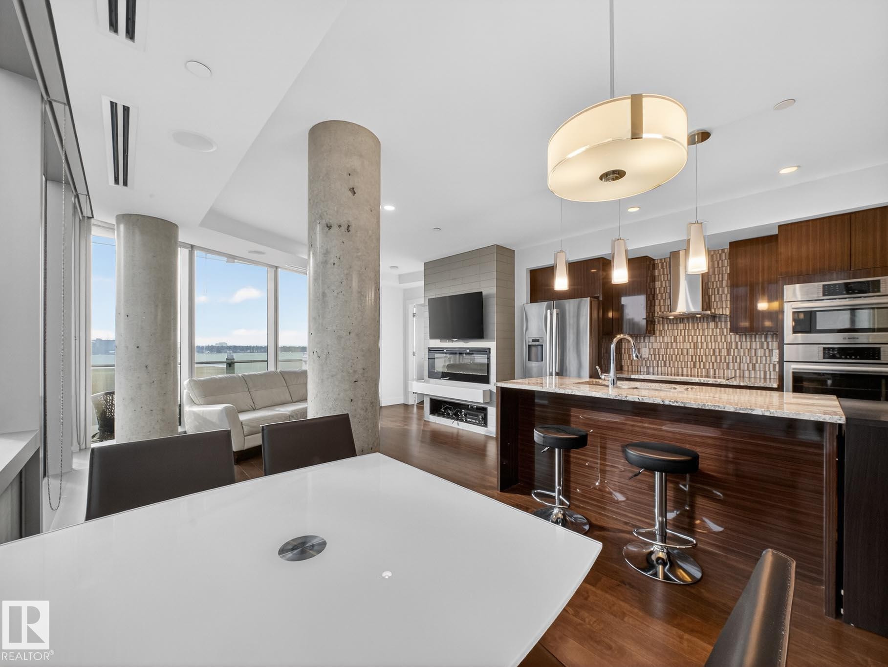 Dining space featuring dark wood-style floors - #902 11969 Jasper Av Nw, Edmonton, AB - Indoor Photo Showing Kitchen With Stainless Steel Kitchen With Upgraded Kitchen