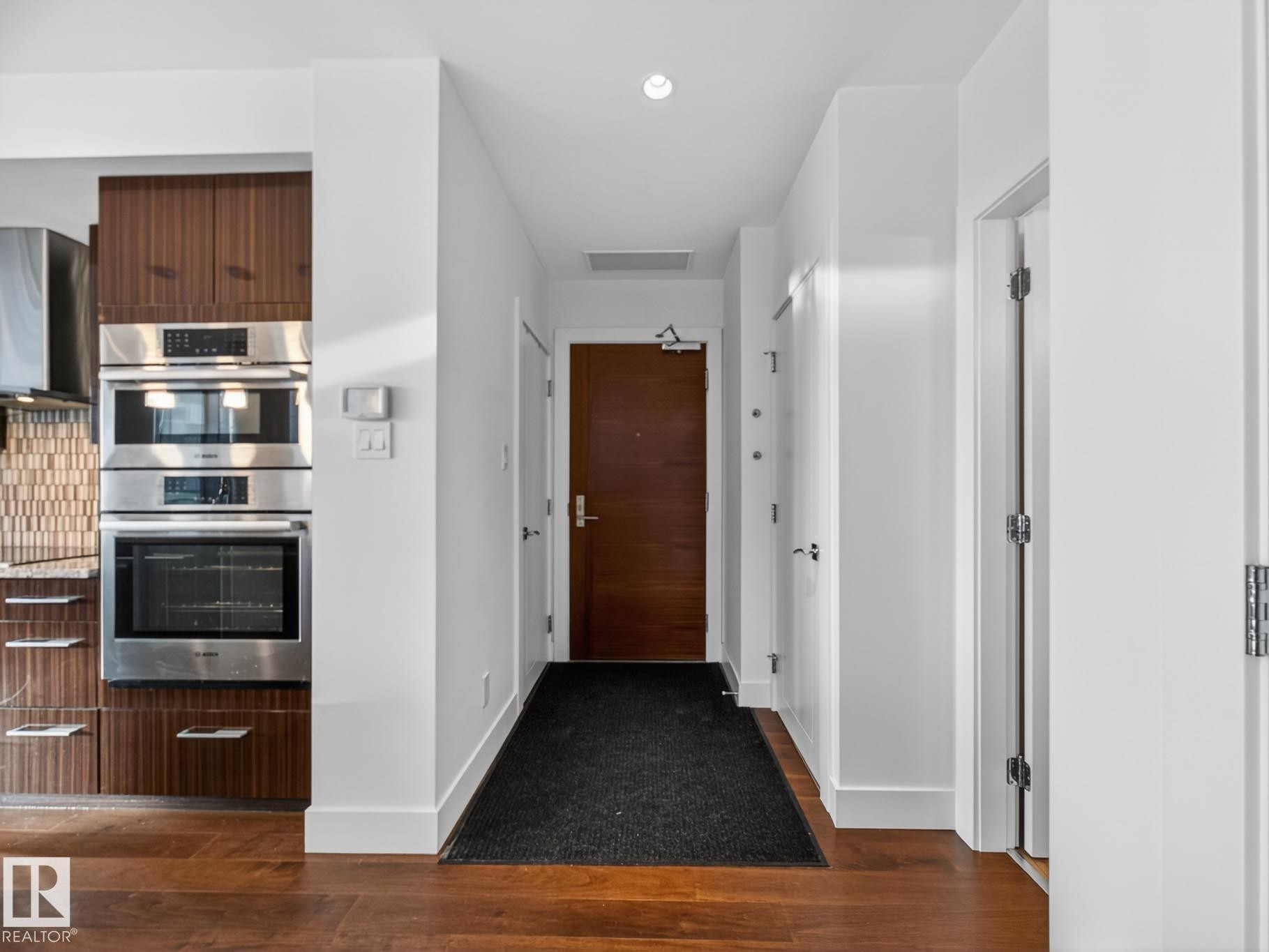 Hall featuring dark wood-style flooring and recessed lighting - #902 11969 Jasper Av Nw, Edmonton, AB - Indoor