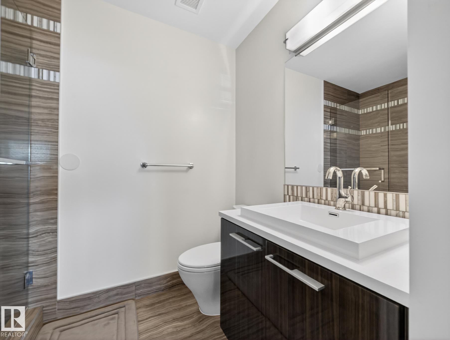 Full bath featuring vanity, a stall shower, and dark wood finished floors - #902 11969 Jasper Av Nw, Edmonton, AB - Indoor Photo Showing Bathroom