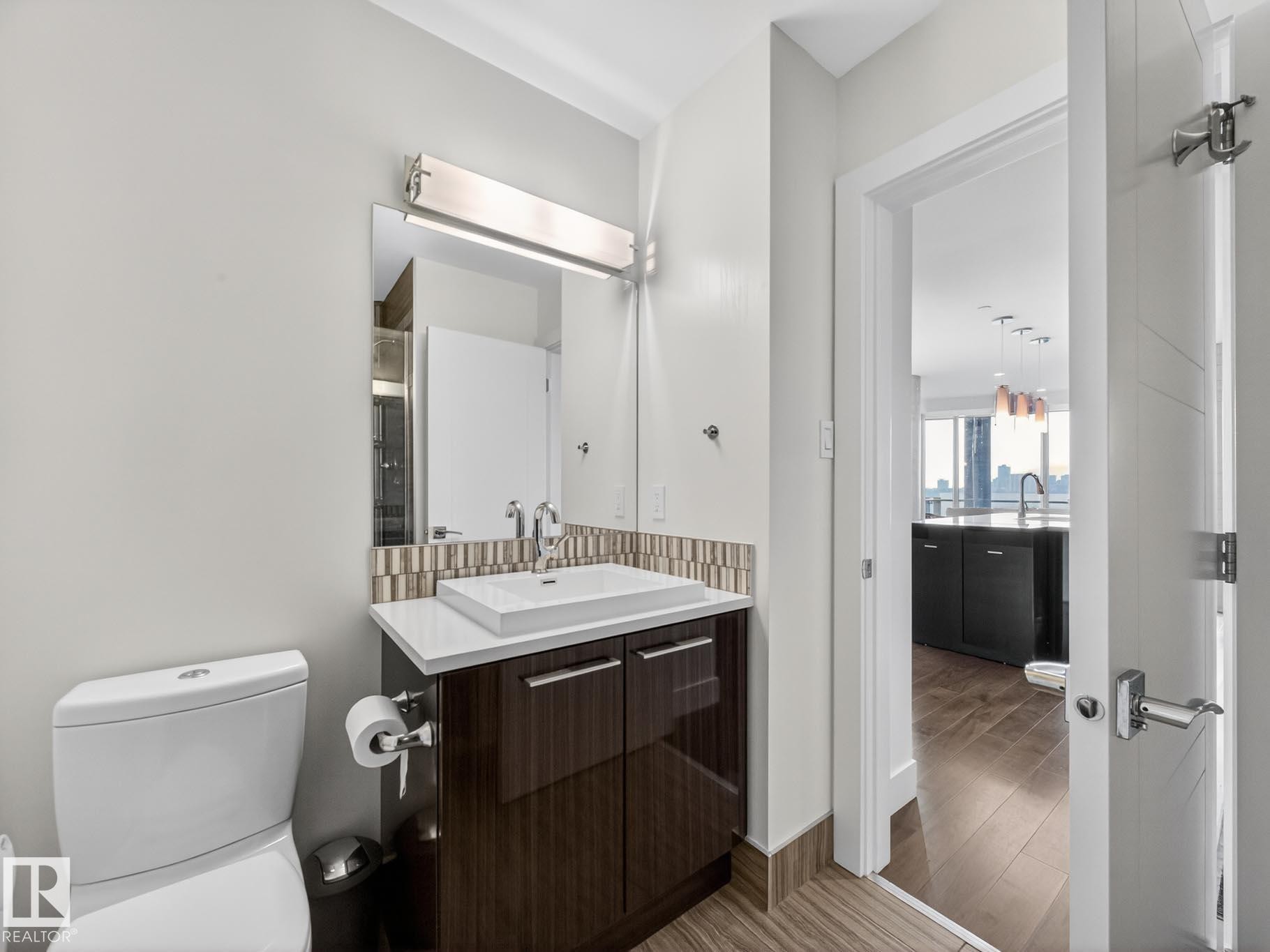 Bathroom with vanity, tasteful backsplash, and light wood-style flooring - #902 11969 Jasper Av Nw, Edmonton, AB - Indoor Photo Showing Bathroom