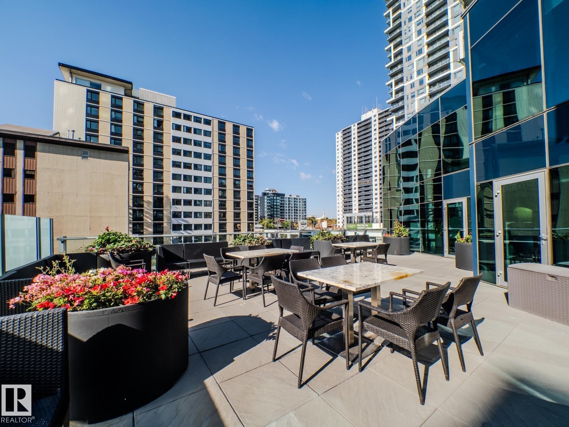 View of patio / terrace with outdoor dining space and a city view - #902 11969 Jasper Av Nw, Edmonton, AB - Outdoor With Facade