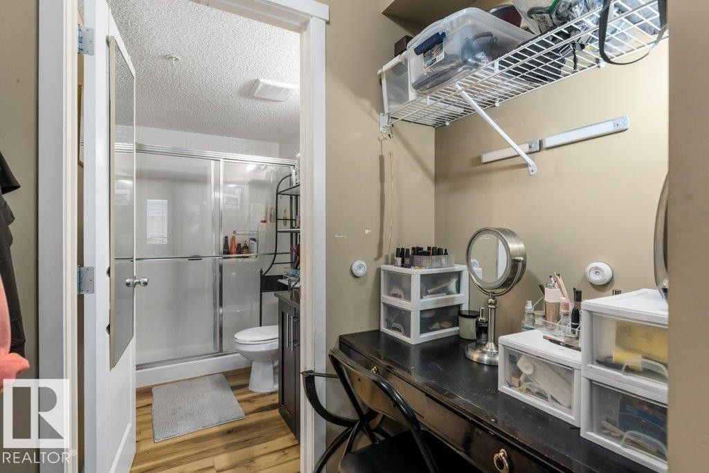 Full bath featuring vanity, a stall shower, wood finished floors, and a textured ceiling - 107 25 Element Dr, St. Albert, AB - Indoor Photo Showing Bathroom
