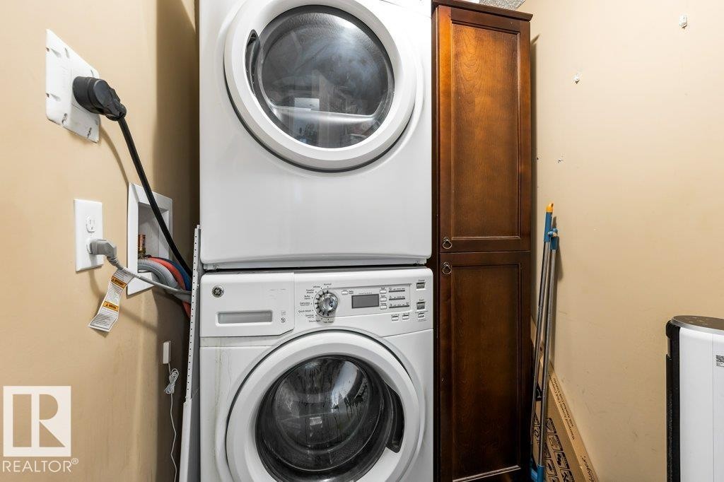Laundry area featuring stacked washing machine and dryer and cabinet space - 107 25 Element Dr, St. Albert, AB - Indoor Photo Showing Laundry Room
