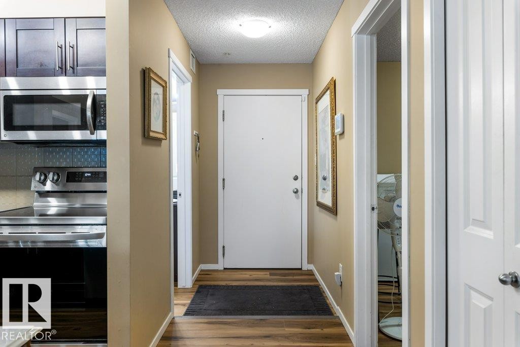 Doorway to outside featuring a textured ceiling and wood finished floors - 107 25 Element Dr, St. Albert, AB - Indoor Photo Showing Other Room
