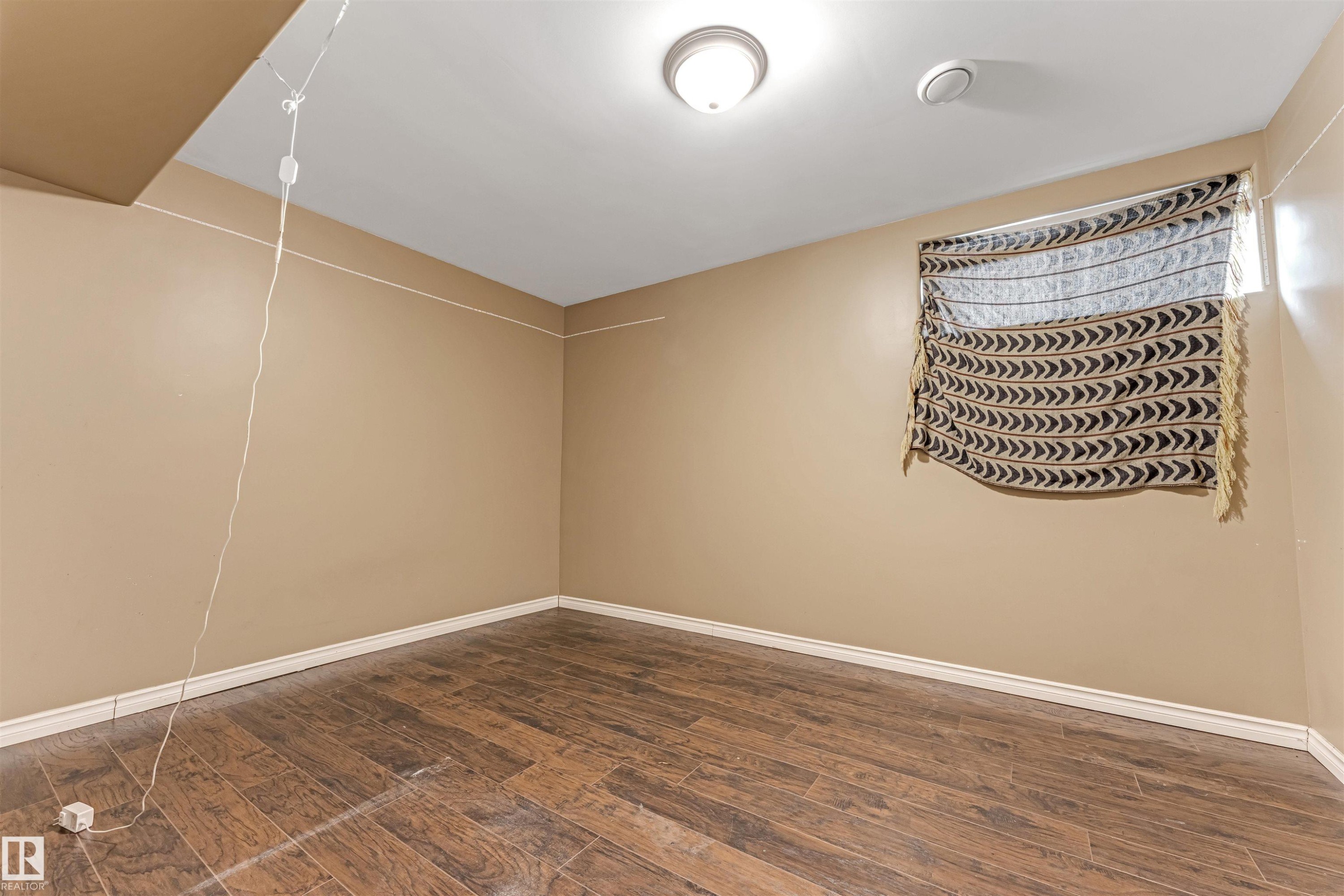 Spare room featuring dark wood-type flooring and baseboards - 6741 162A Avenue, Edmonton, AB - Indoor Photo Showing Other Room