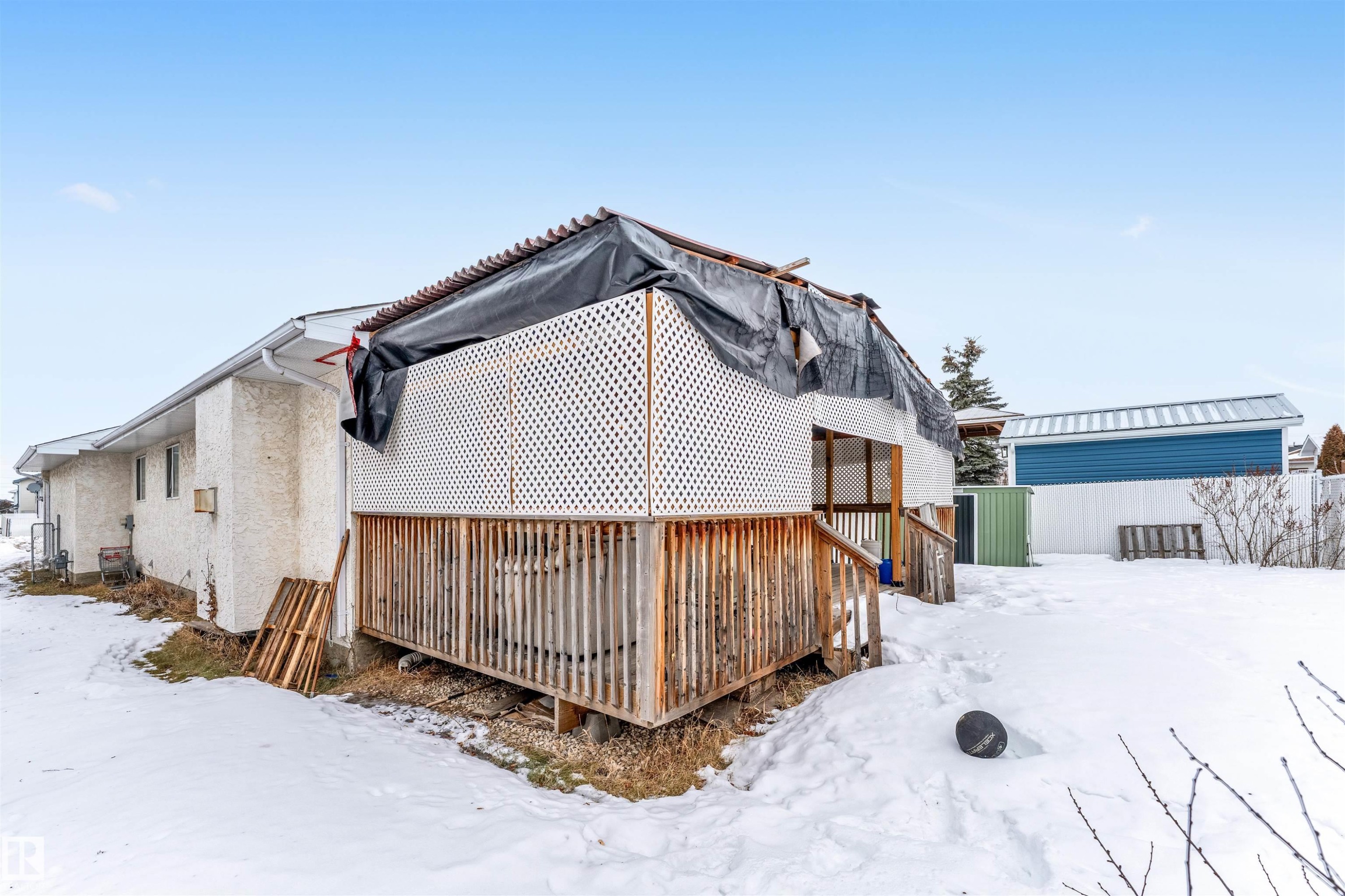 Snow covered property featuring a wooden deck and stucco siding - 6741 162A Avenue, Edmonton, AB - Outdoor