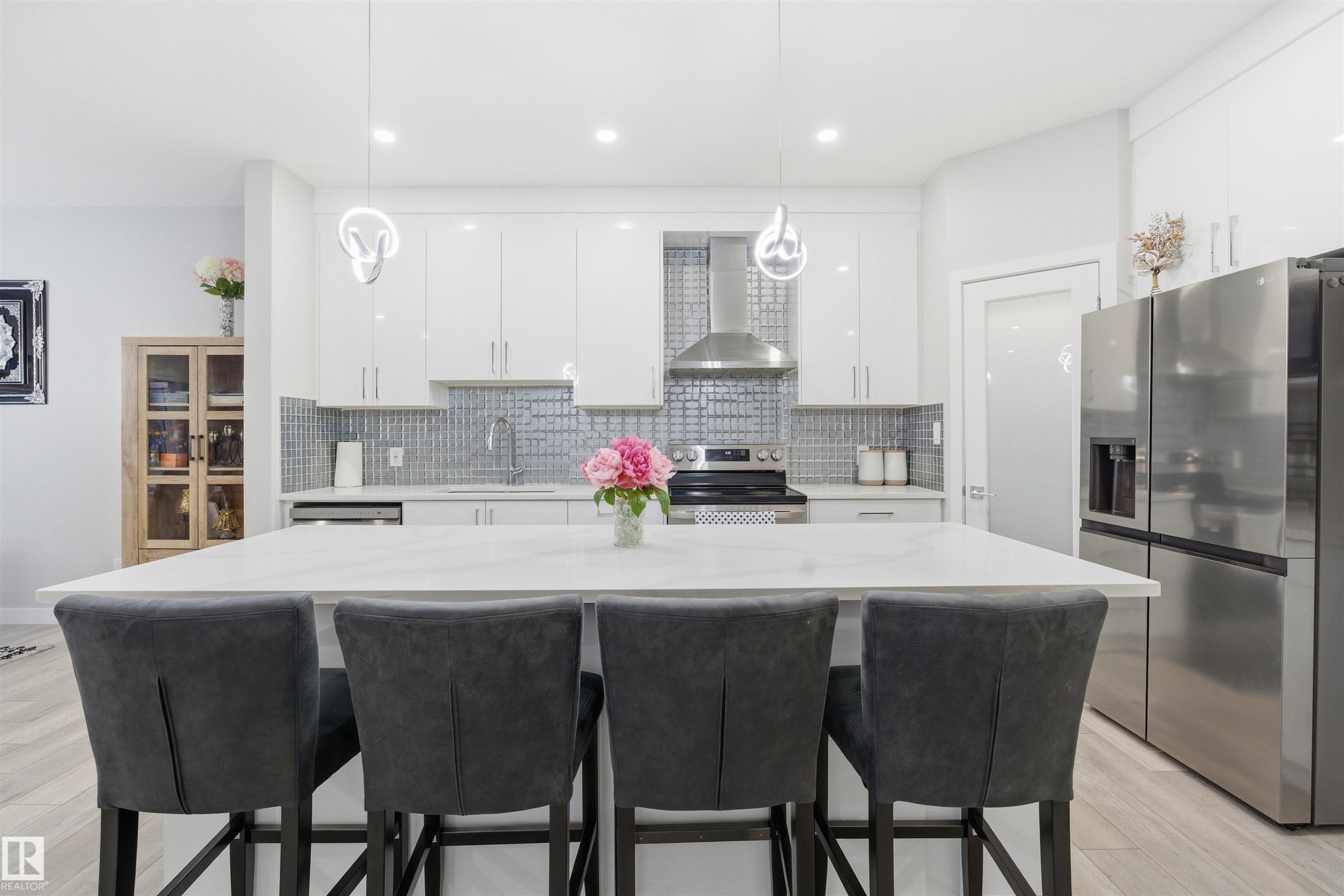 Kitchen featuring white cabinetry, stainless steel appliances, light wood-type flooring, and recessed lighting - 452 Roberts Crescent, Leduc, AB - Indoor Photo Showing Other Room