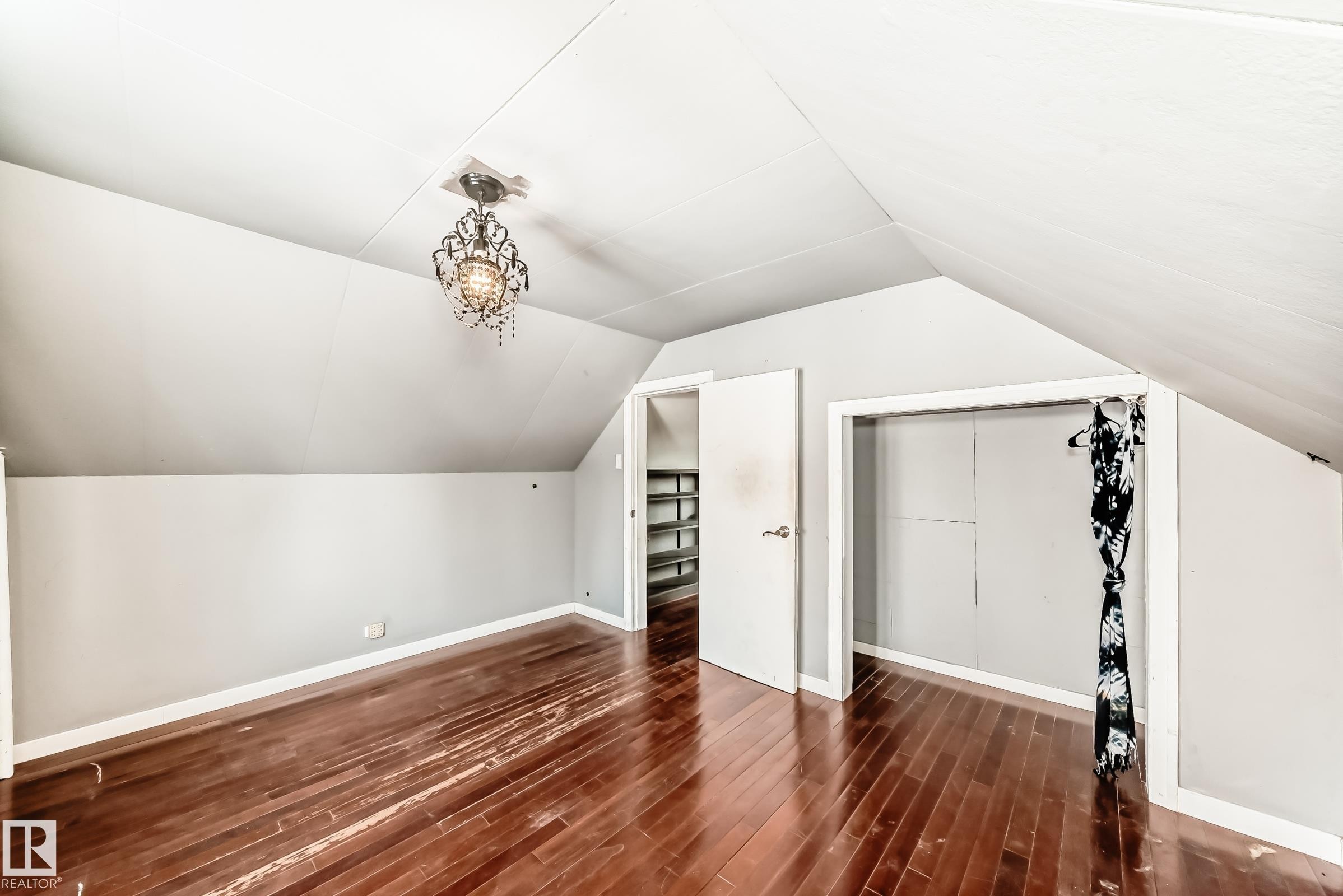 Bonus room featuring dark wood-style floors and vaulted ceiling - 10115 104, Westlock, AB - Indoor Photo Showing Other Room