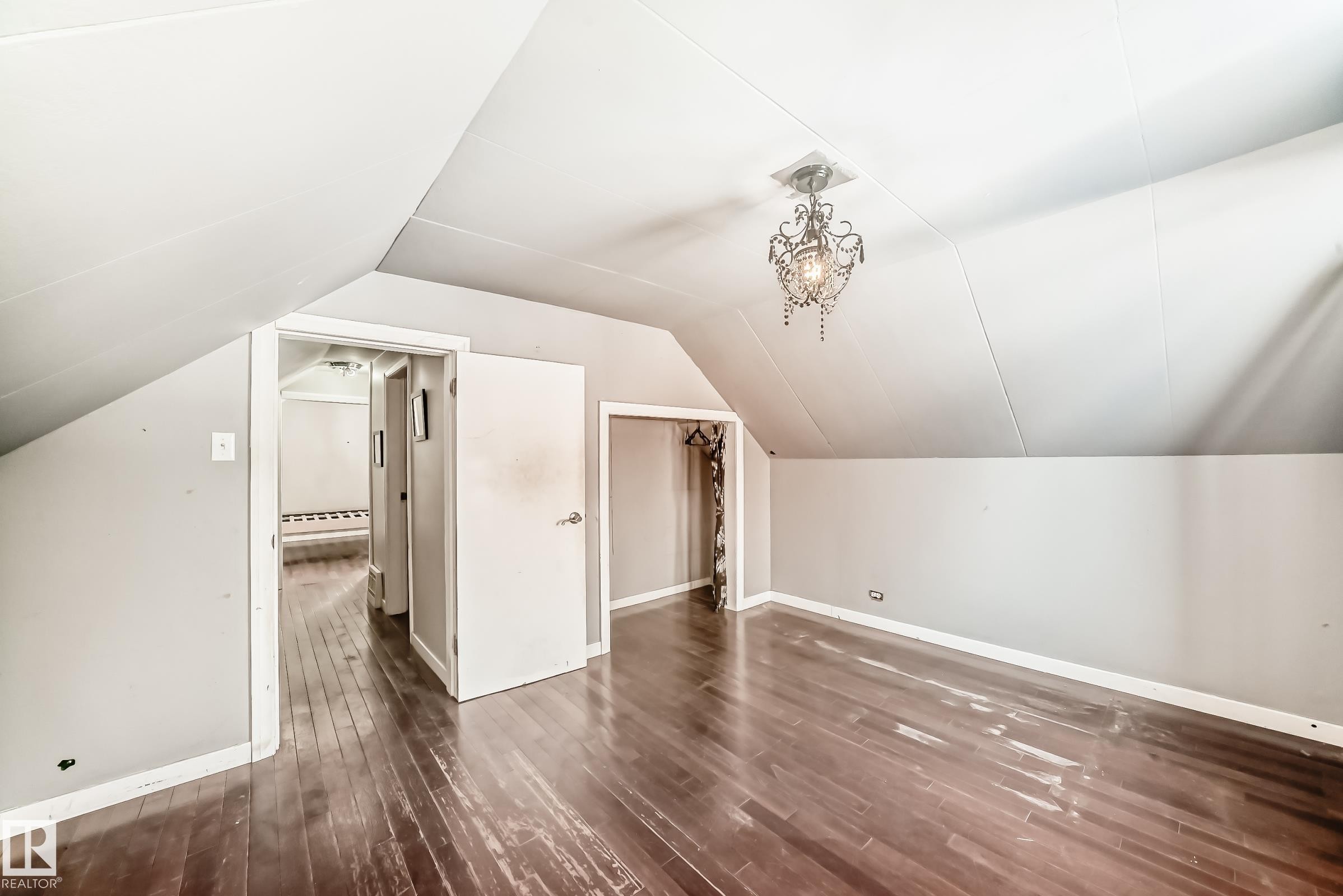 Bonus room featuring dark wood-style flooring and vaulted ceiling - 10115 104, Westlock, AB - Indoor Photo Showing Other Room