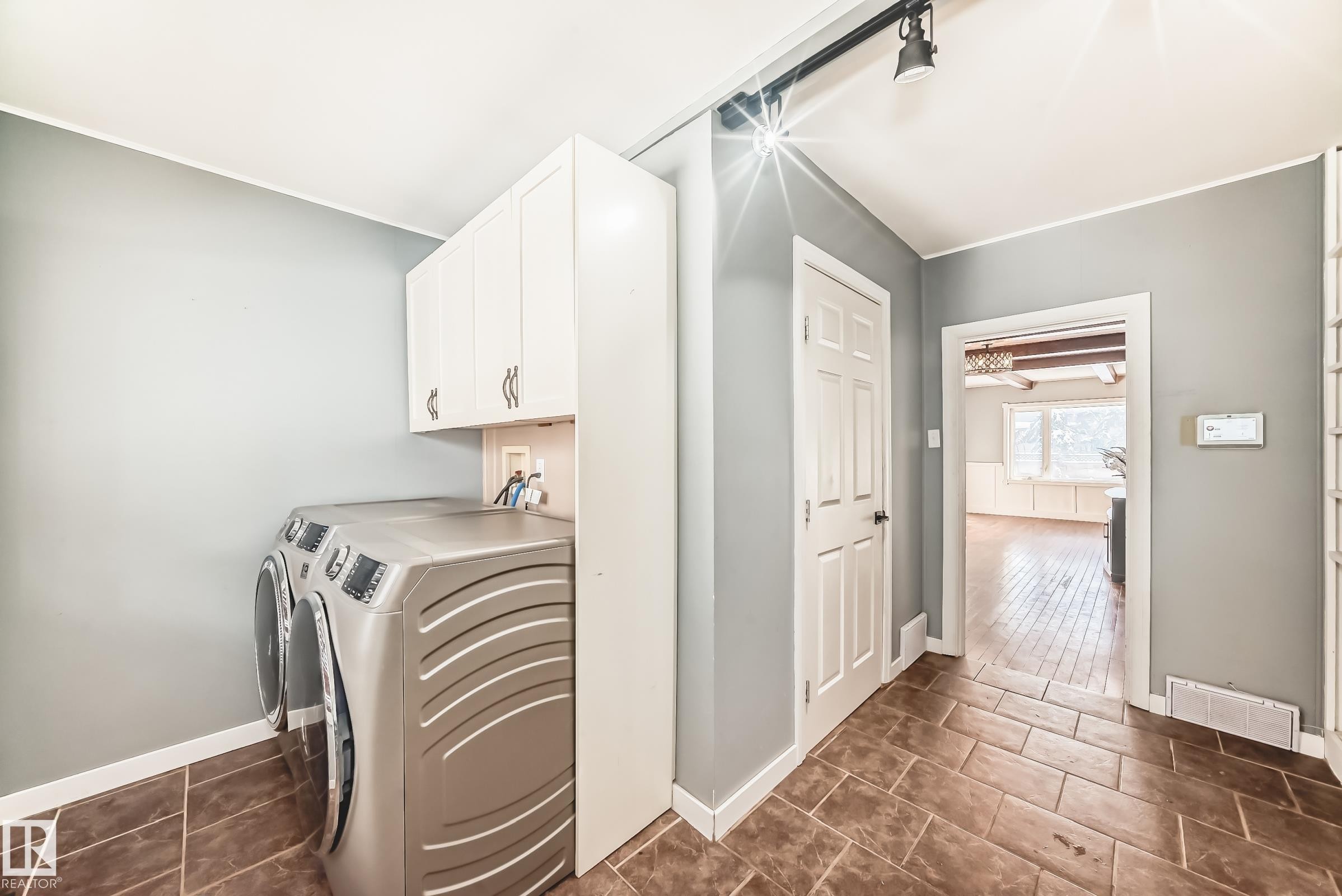 Laundry area with washing machine and clothes dryer, cabinet space, and crown molding - 10115 104, Westlock, AB - Indoor Photo Showing Laundry Room