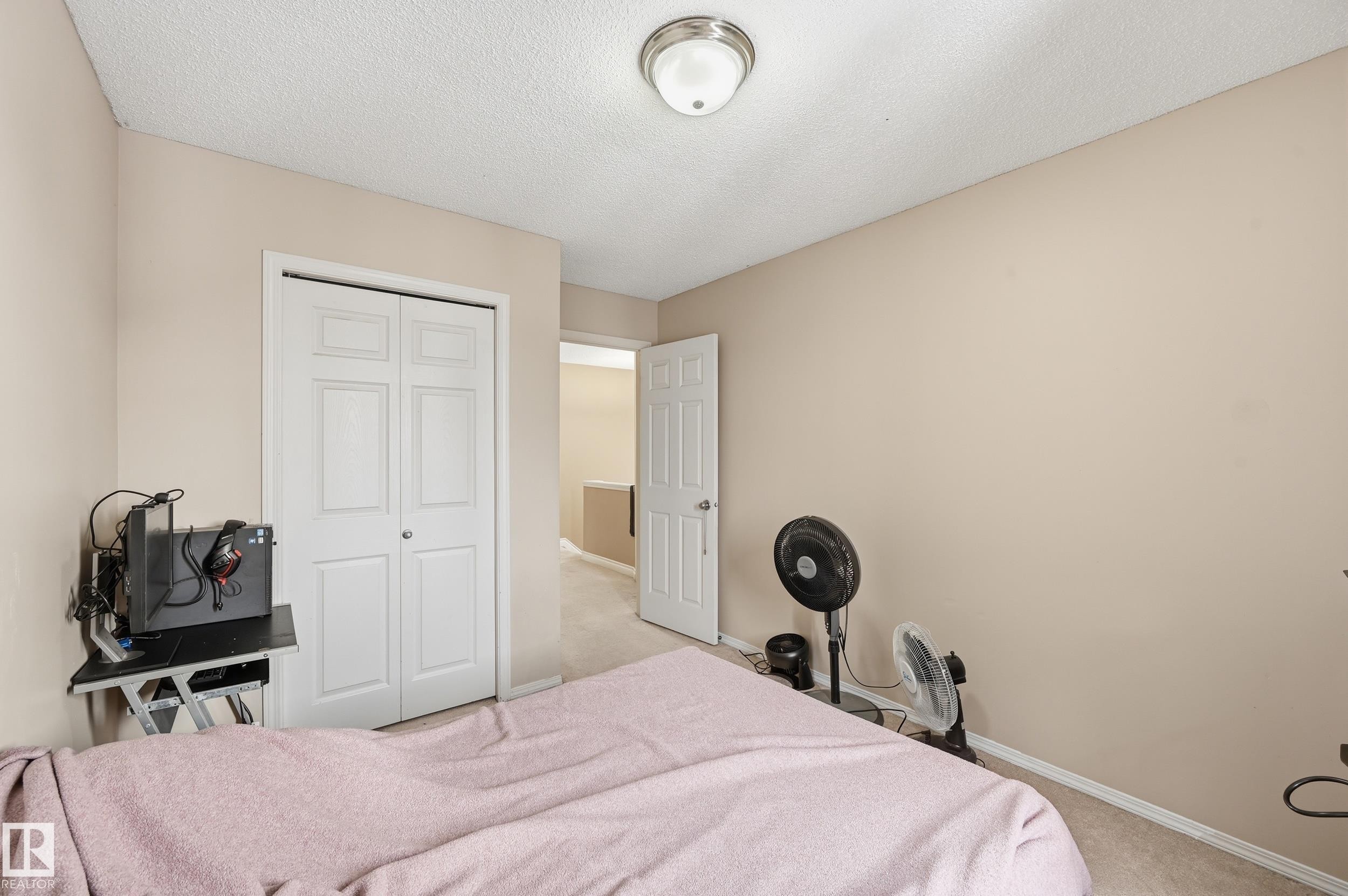 Bedroom with a textured ceiling, light colored carpet, and a closet - 3010 32 Avenue Nw, Edmonton, AB - Indoor Photo Showing Bedroom