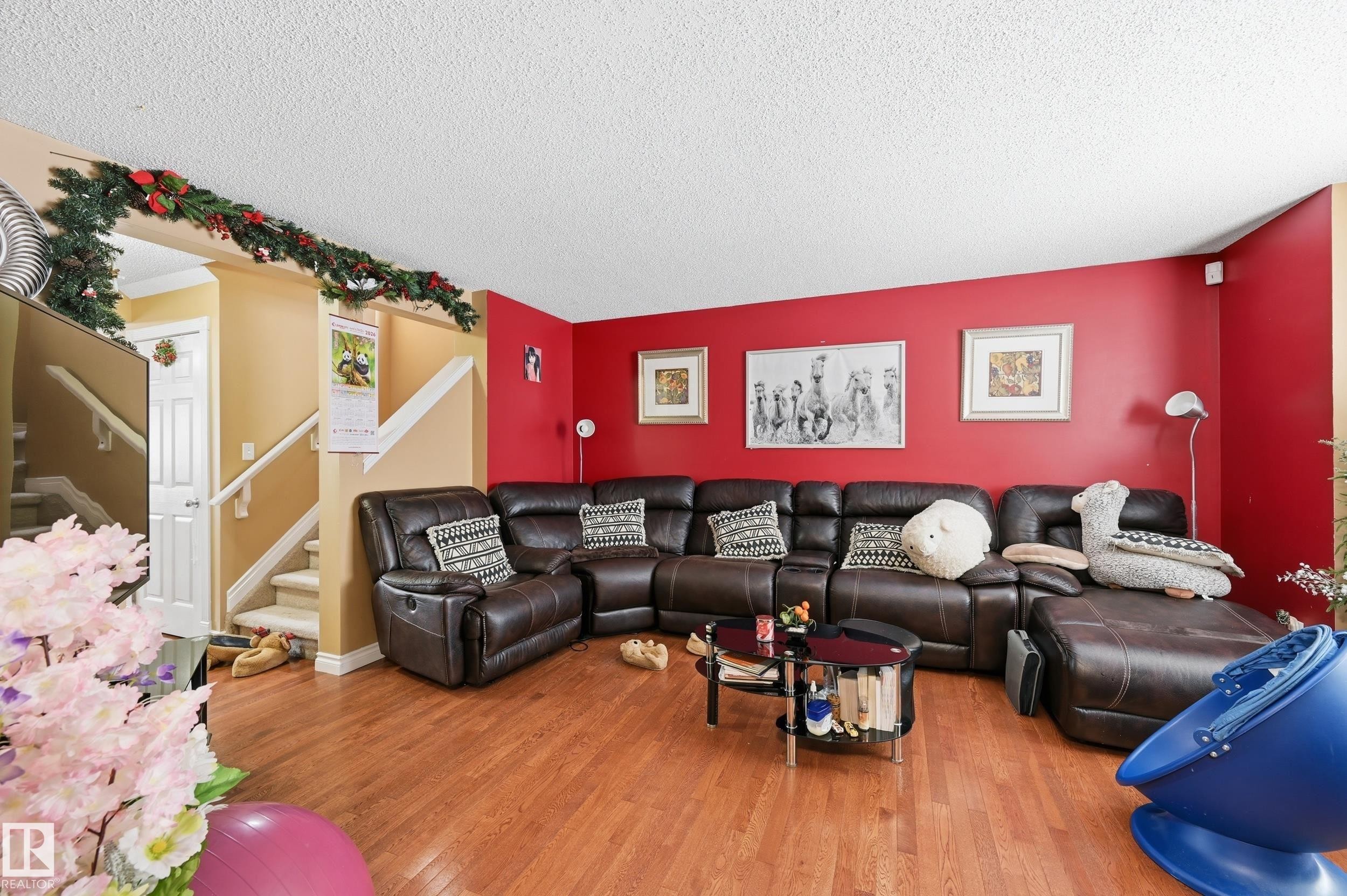 Living room with stairs, wood finished floors, and a textured ceiling - 3010 32 Avenue Nw, Edmonton, AB - Indoor Photo Showing Living Room