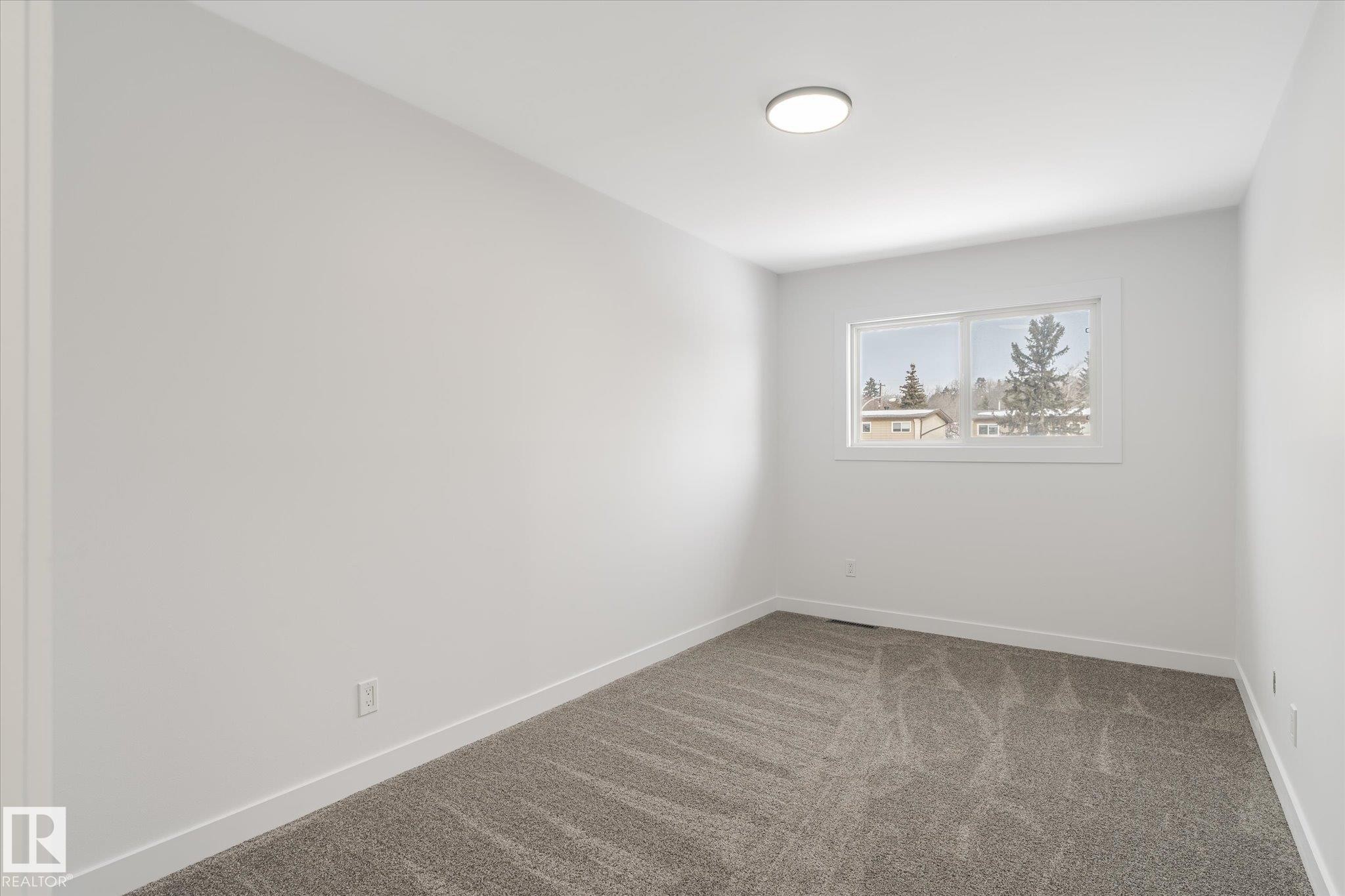 Spare room featuring carpet flooring and baseboards - 5105 106A Street, Edmonton, AB - Indoor Photo Showing Other Room