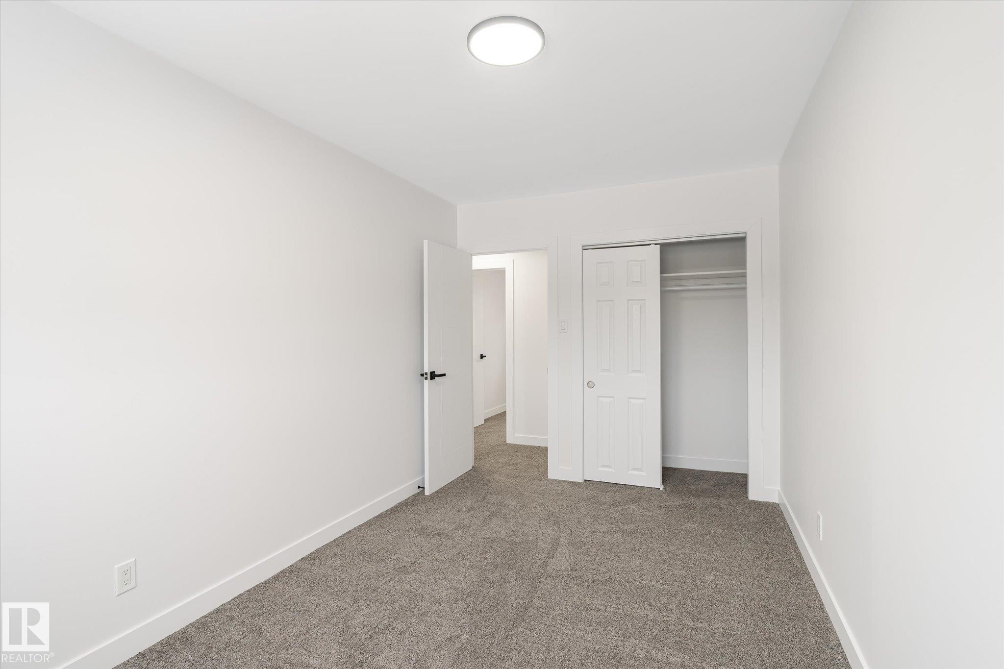 Unfurnished bedroom featuring carpet flooring and a closet - 5105 106A Street, Edmonton, AB - Indoor Photo Showing Other Room