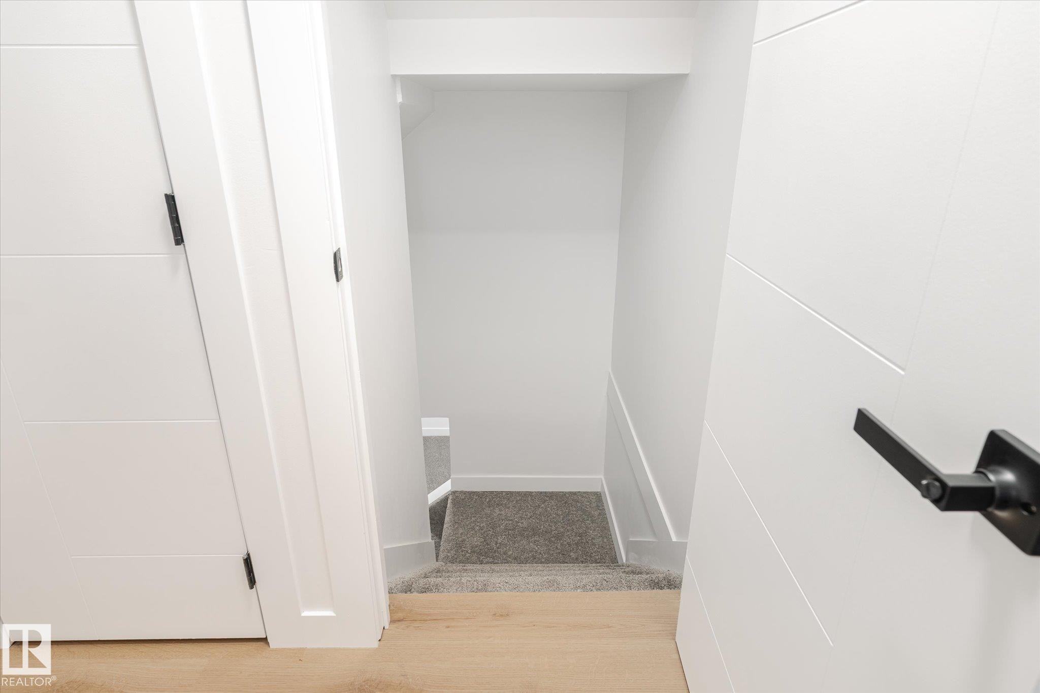 Staircase with wood finished floors and baseboards - 5105 106A Street, Edmonton, AB - Indoor Photo Showing Other Room