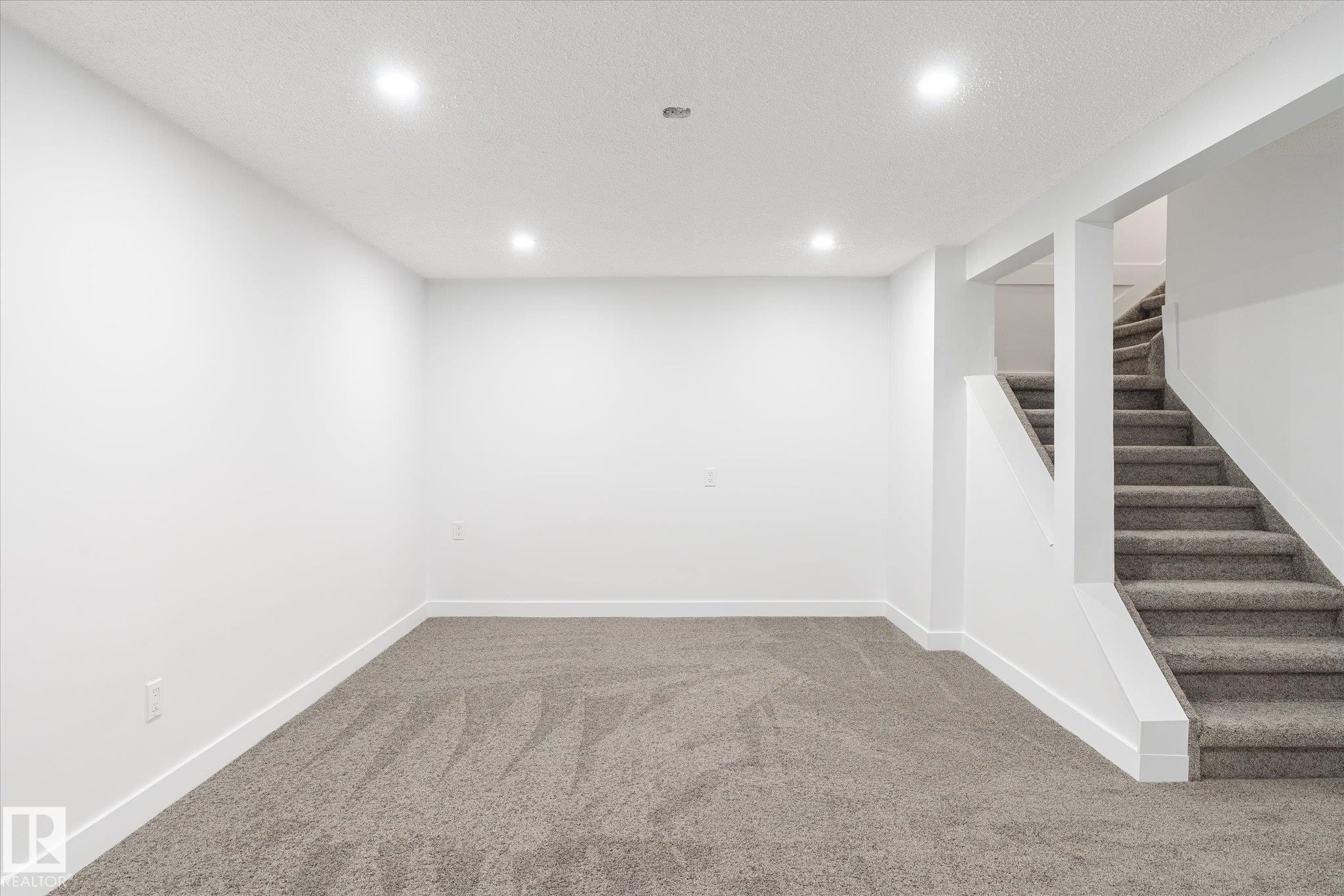 Finished basement featuring carpet, stairs, recessed lighting, and a textured ceiling - 5105 106A Street, Edmonton, AB - Indoor Photo Showing Other Room