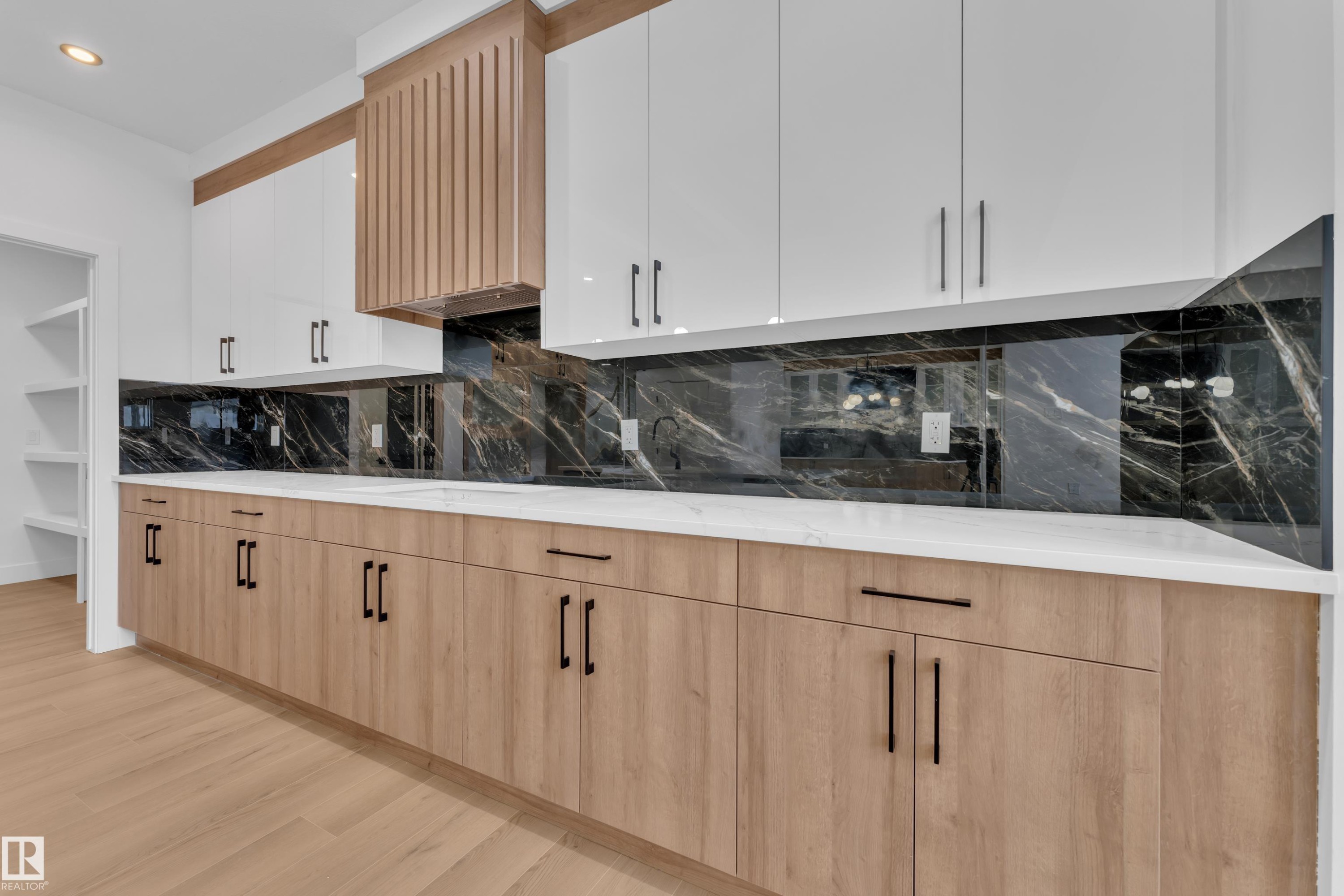 Kitchen with two tone cabinetry, decorative backsplash, modern cabinets, light wood-type flooring, and light stone counters - 733 Astoria Way, Devon, AB - Indoor Photo Showing Kitchen