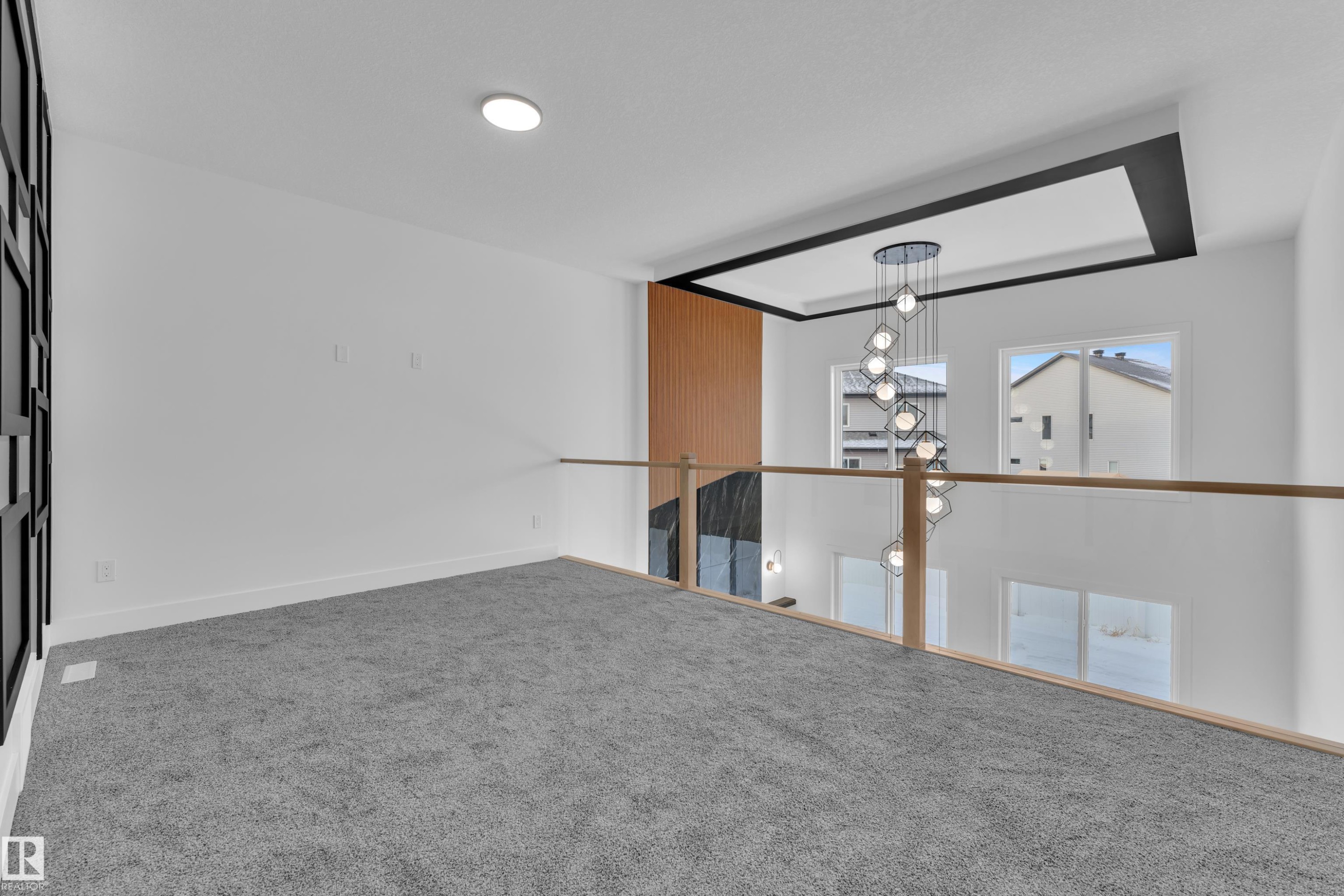 Empty room with carpet flooring and hanging lights - 733 Astoria Way, Devon, AB - Indoor Photo Showing Other Room