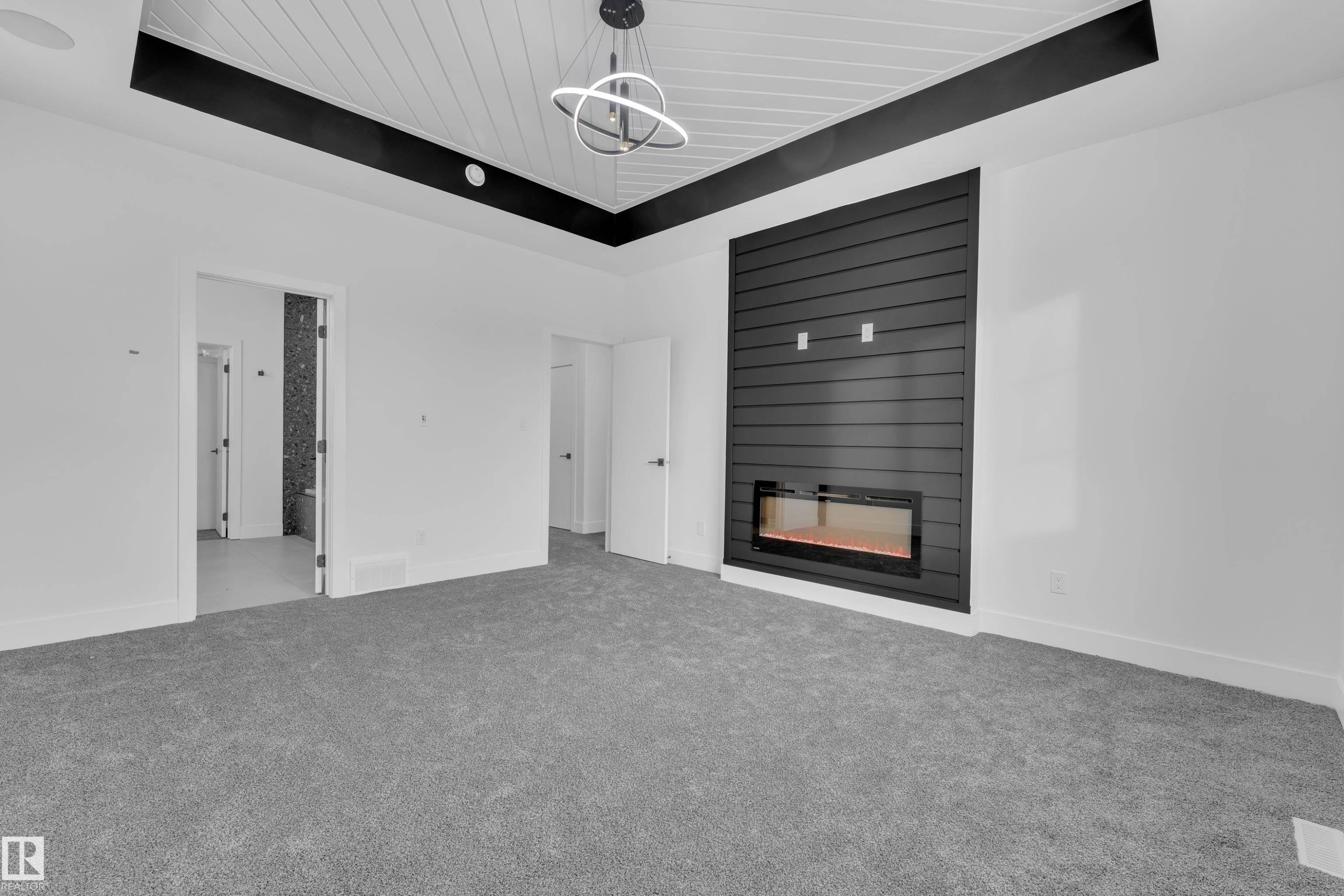 Unfurnished living room with carpet, a fireplace, and a wooden tray ceiling - 733 Astoria Way, Devon, AB - Indoor Photo Showing Other Room