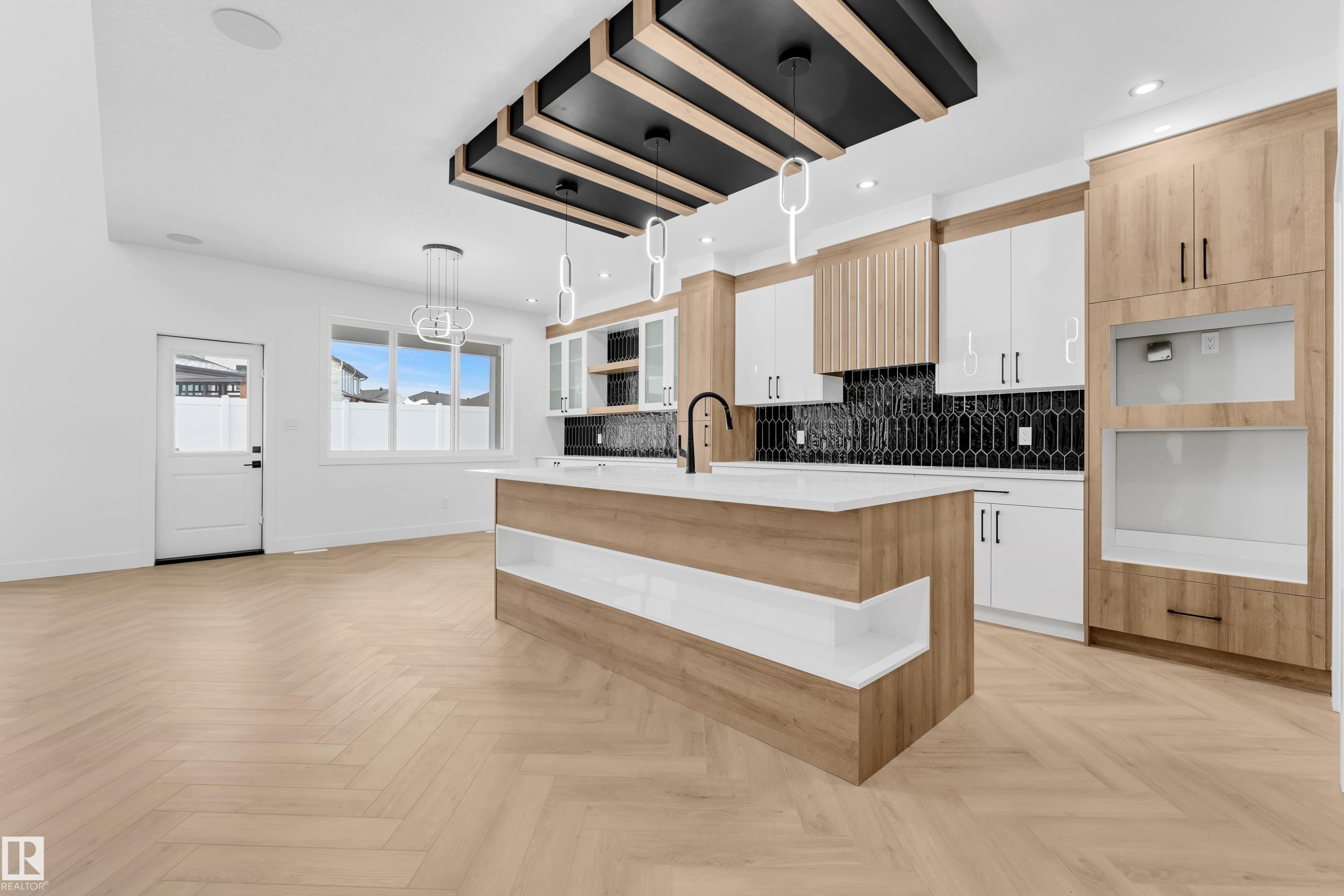 Two tone kitchen featuring two tone cabinets, hanging light fixtures, a center island with sink, open shelves, and decorative backsplash - 737 Astoria Way, Devon, AB - Indoor Photo Showing Kitchen